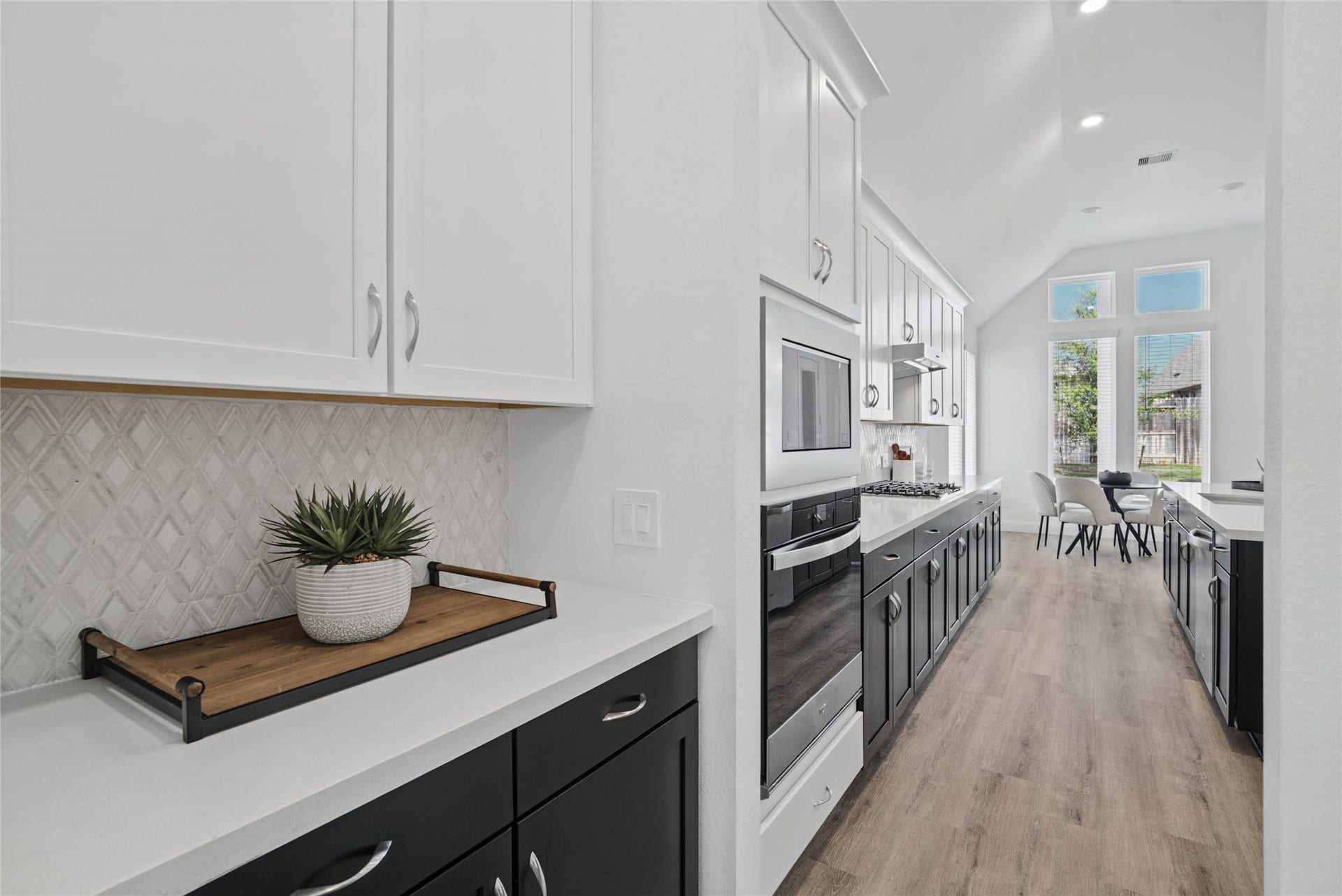 This gorgeous butler pantry area is perfect for quick access when entertaining friends and family. Featuring a popular "tuxedo" style, pairing crisp white upper cabinets with deep black lower cabinets to create visual depth and a modern aesthetic.
