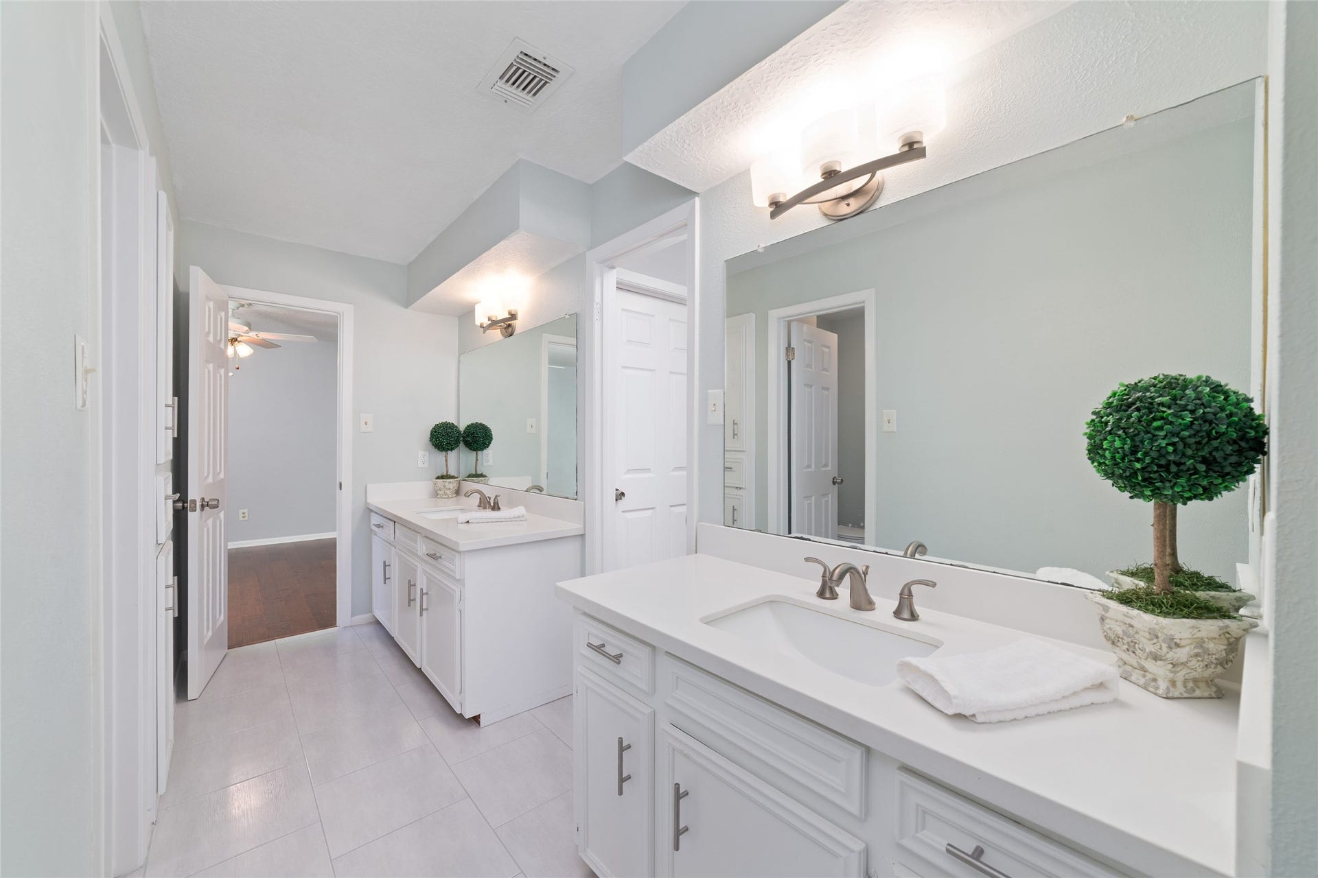 13007 New Cypress Drive, Cypress, TX 77429 Another view of the spacious Jack-and-Jill bathroom, featuring separate vanity areas with individual sinks, oversized mirrors, and generous cabinet storage. A thoughtfully designed layout provides personal space for each bedroom while sharing a central bathing area