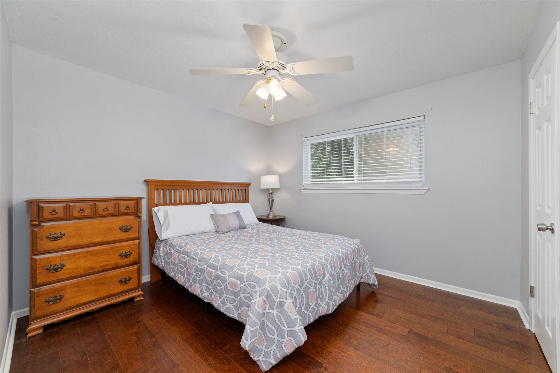 13007 New Cypress Drive, Cypress, TX 77429 Comfortable upstairs secondary bedroom featuring rich wood floors, a window overlooking the backyard, ceiling fan, and spacious walk-in closet. Plenty of room for bedroom furnishings while maintaining an open, inviting feel