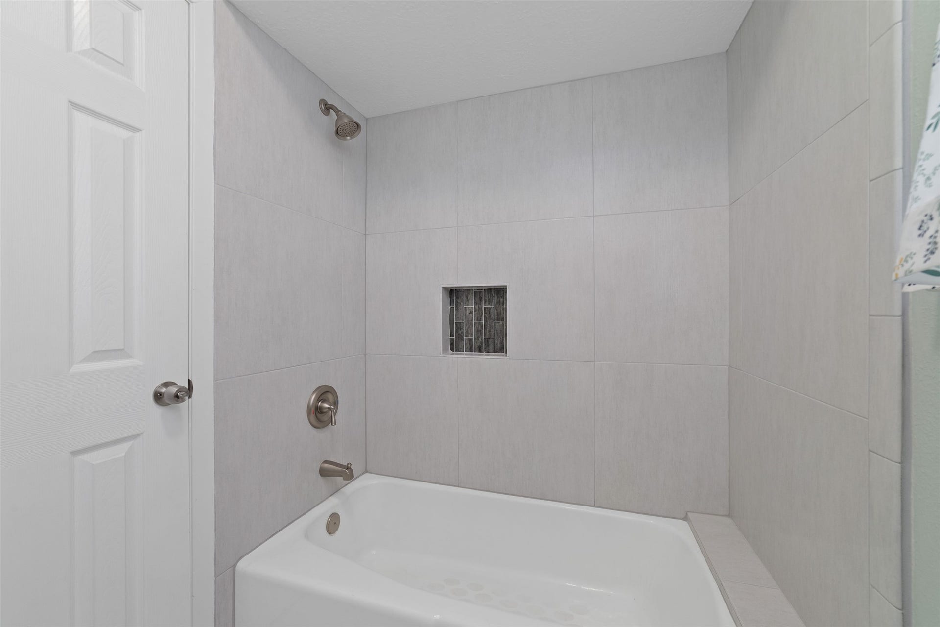 13007 New Cypress Drive, Cypress, TX 77429 Updated shared tub/shower features a fresh, contemporary tile surround, brushed nickel fixtures, and a recessed shampoo niche with decorative mosaic tile accents