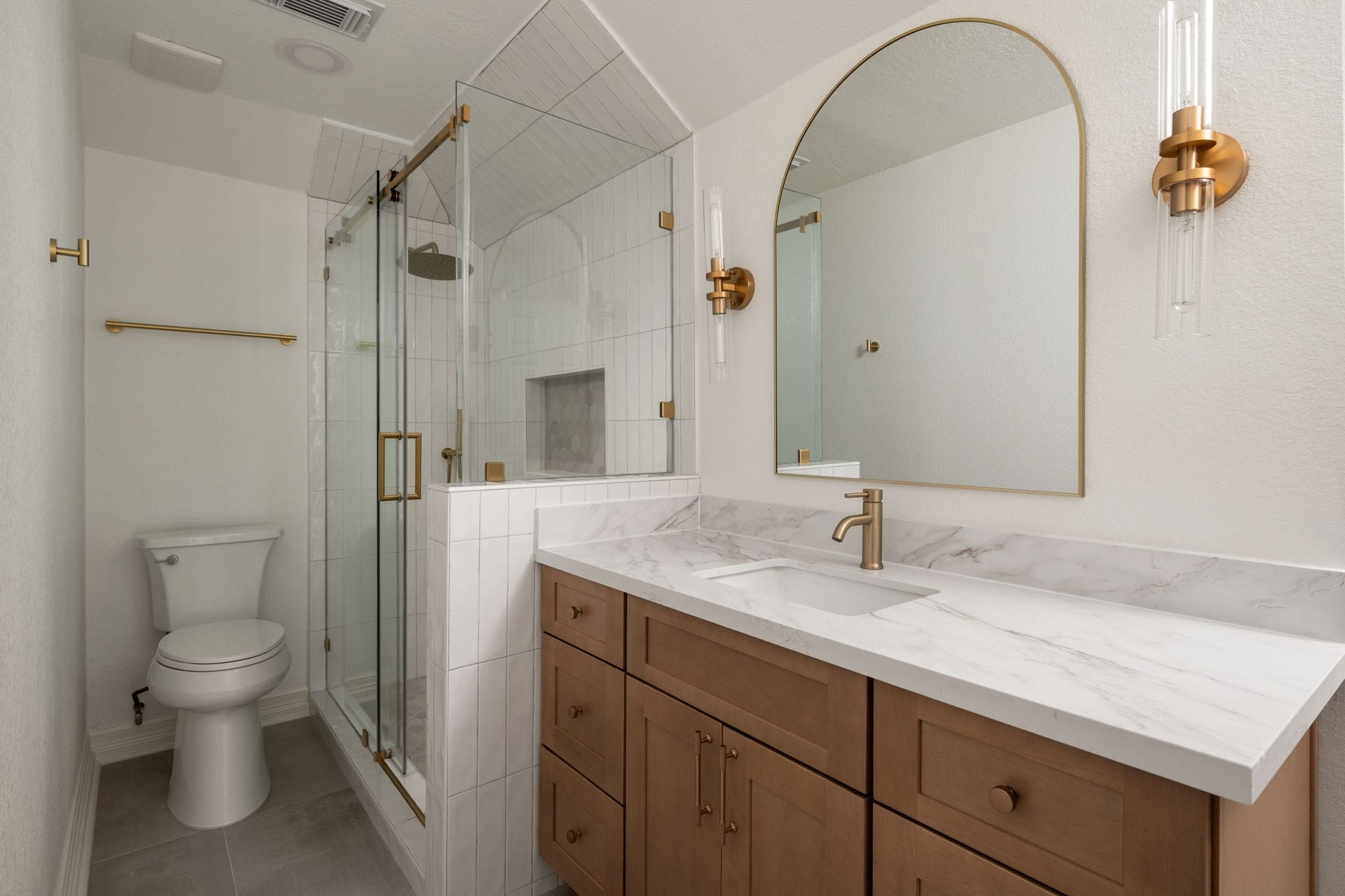 93 Greensward Lane, Sugar Land, TX 77479 Secondary bathrooms combine updated cabinetry, contemporary fixtures, and frameless glass shower enclosures within clean, modern layouts. Quartz surfaces and designer lighting add contrast and texture throughout the spaces. Functional storage and updated finishes enhance everyday usability.