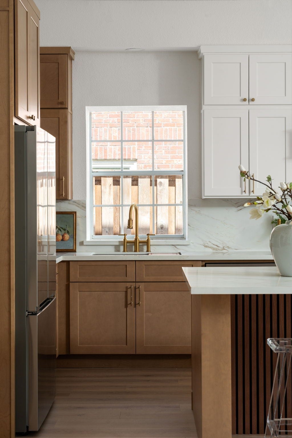 93 Greensward Lane, Sugar Land, TX 77479 Large windows bring natural light into the kitchen while highlighting the updated finishes and custom cabinetry. Quartz countertops, brass fixtures, and integrated storage contribute to the kitchens modern functionality. The layout was designed to maintain connection to the homes main entertaining spaces.