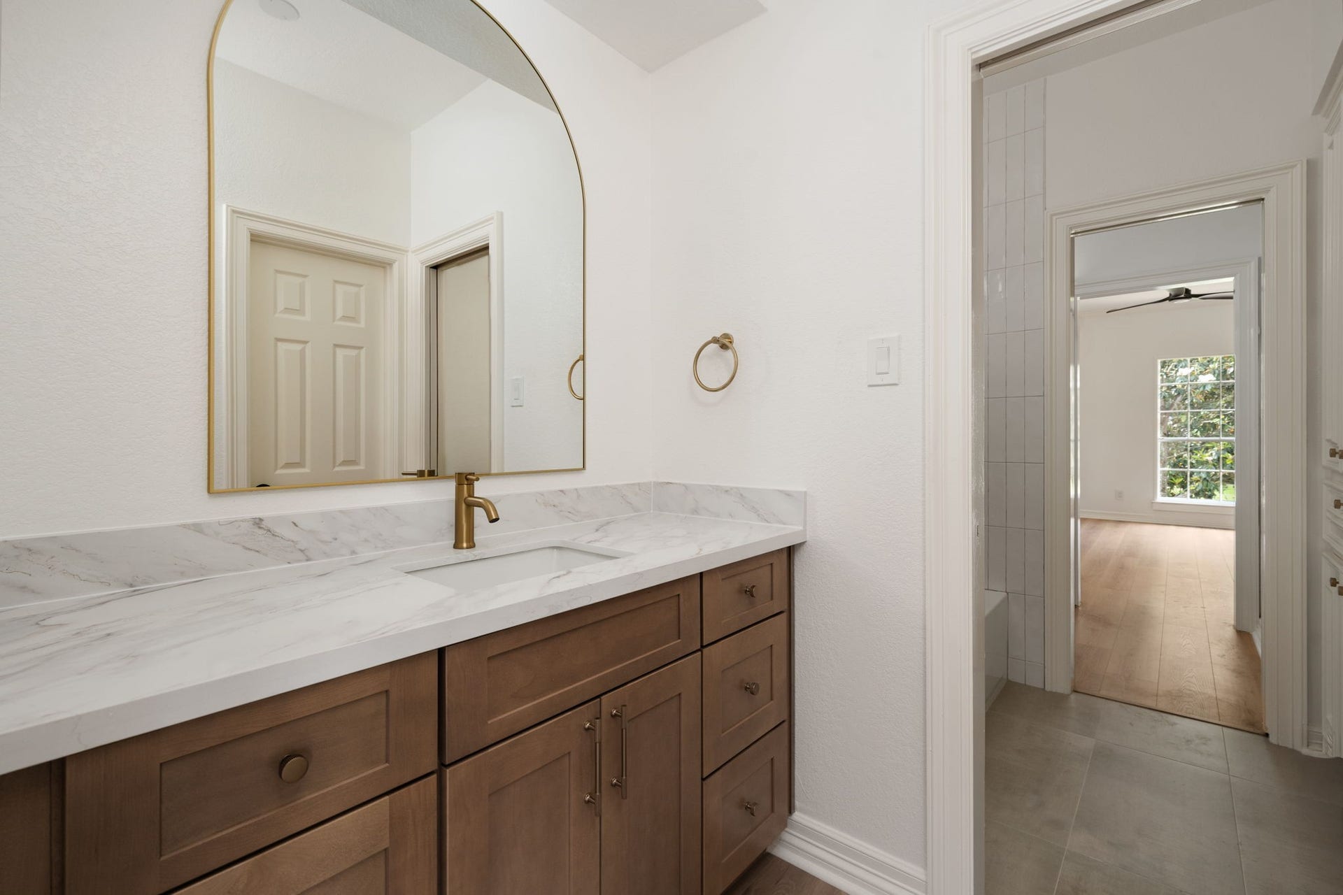93 Greensward Lane, Sugar Land, TX 77479 Renovated secondary bathrooms feature updated vanity cabinetry, quartz surfaces, and frameless glass shower enclosures. Designer lighting and contemporary fixtures elevate the spaces while maintaining everyday functionality. Clean finishes and integrated storage continue throughout the bathrooms.