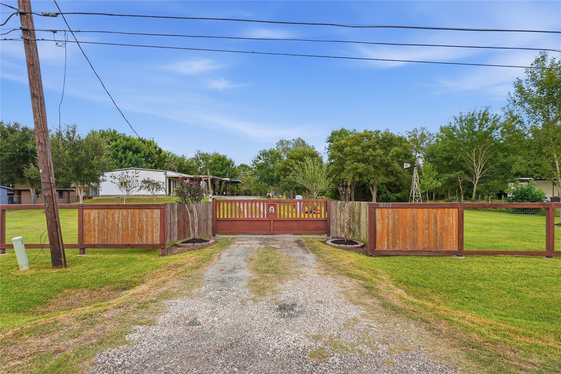 18503 Frazier Drive, #C176C, Pearland, TX 77584 Private gated entrance opening to a long driveway and beautifully maintained lawn surrounding mature trees.