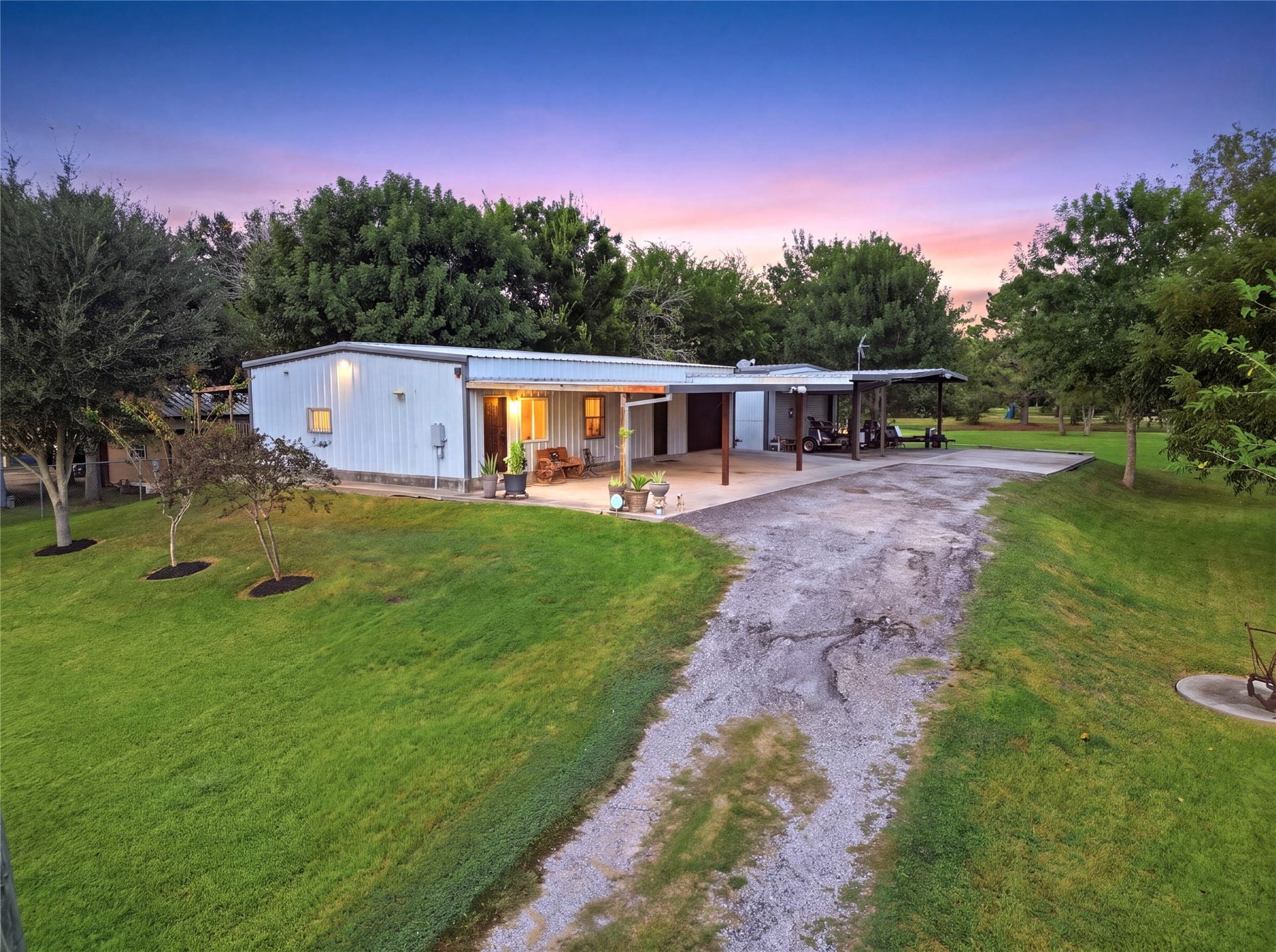 18503 Frazier Drive, #C176C, Pearland, TX 77584 Peaceful exterior view of the home at sunset, showcasing the large lawn, mature trees, cover patio and parking areas, and spacious property setting.