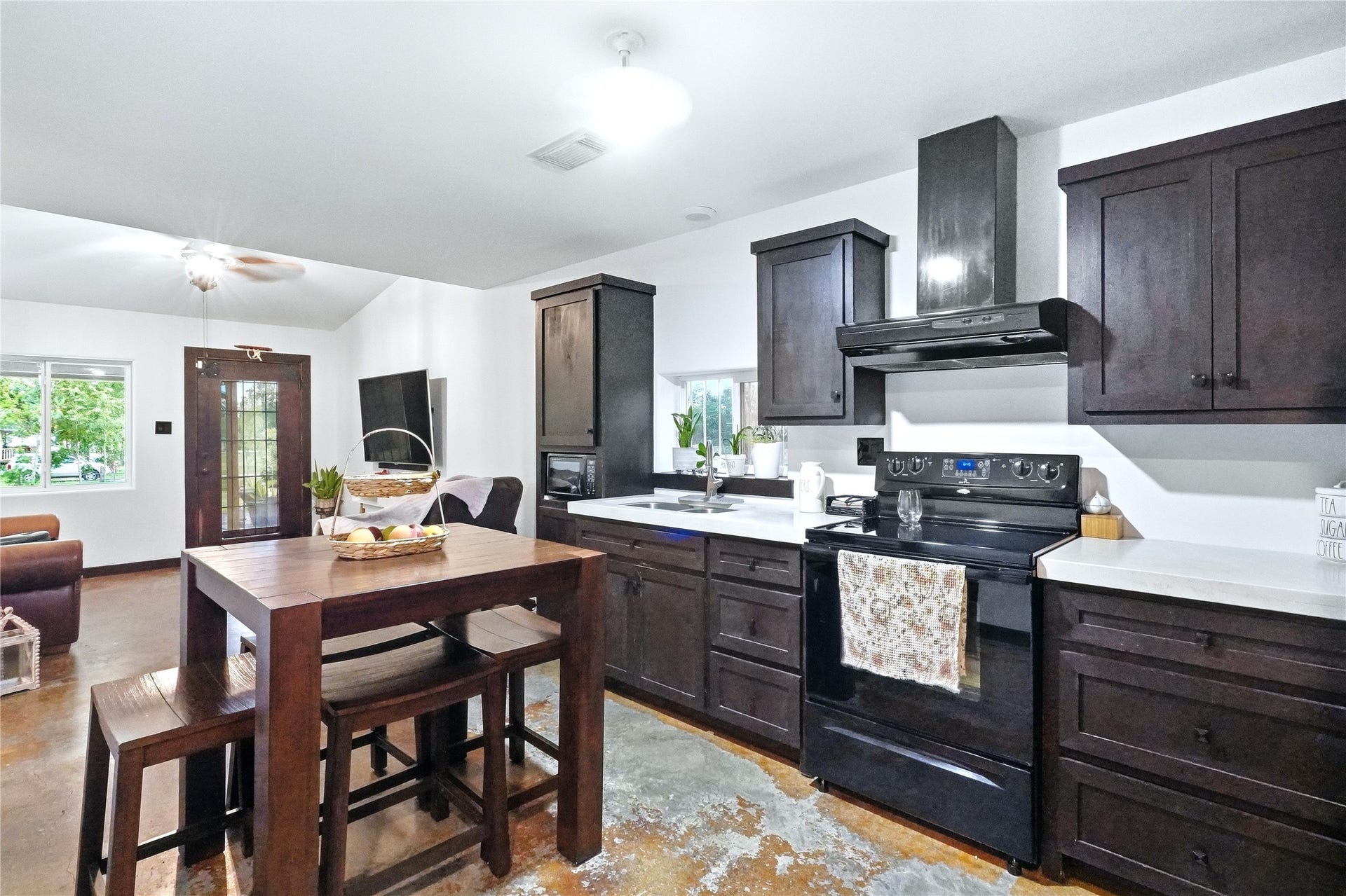 18503 Frazier Drive, #C176C, Pearland, TX 77584 Functional kitchen featuring dark cabinetry, light countertops, black appliances, abundant cabinet storage, and a convenient dining area.