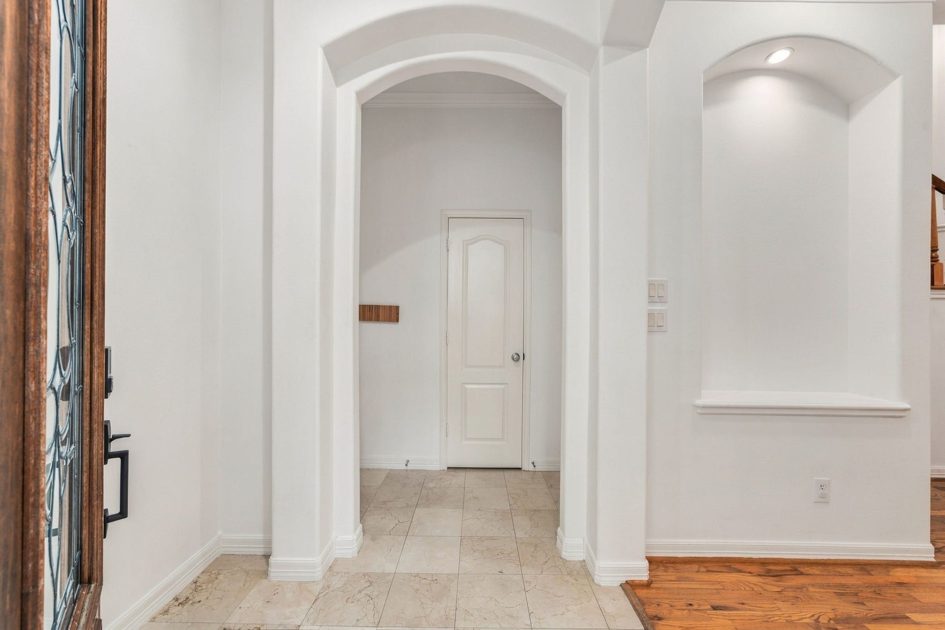 6113 Maxie Street, Houston, TX 77007 A welcoming entry featuring graceful archways, a decorative front door & elegant crown molding, with a combination of tile & hardwood flooring that adds warmth and character to the home.