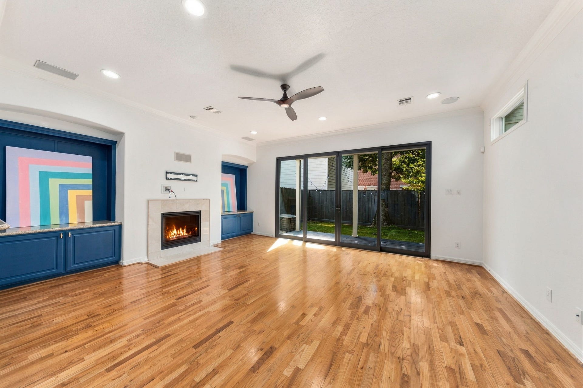 6113 Maxie Street, Houston, TX 77007 Another perspective highlighting the fireplace, distinctive blue built-in cabinetry & wide sliding glass doors overlooking the backyard.