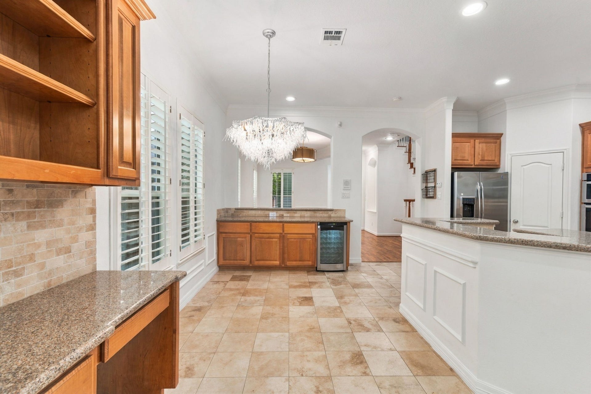 6113 Maxie Street, Houston, TX 77007 An open connection between the formal dining room, breakfast area & kitchen creates an easy flow for entertaining. A dedicated butler's bar with built-in wine fridge, additional cabinetry & a convenient built-in desk adds both style and functionality.