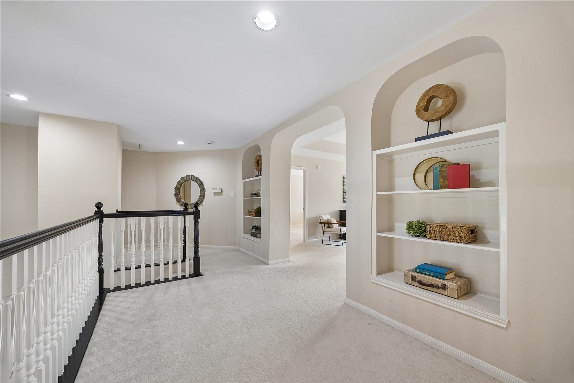7503 Stone Arbor Drive, Sugar Land, TX 77479 The spacious upstairs landing is accented by elegant arched niches with built-in shelving, creating an inviting transition between the home's secondary living spaces and bedrooms.