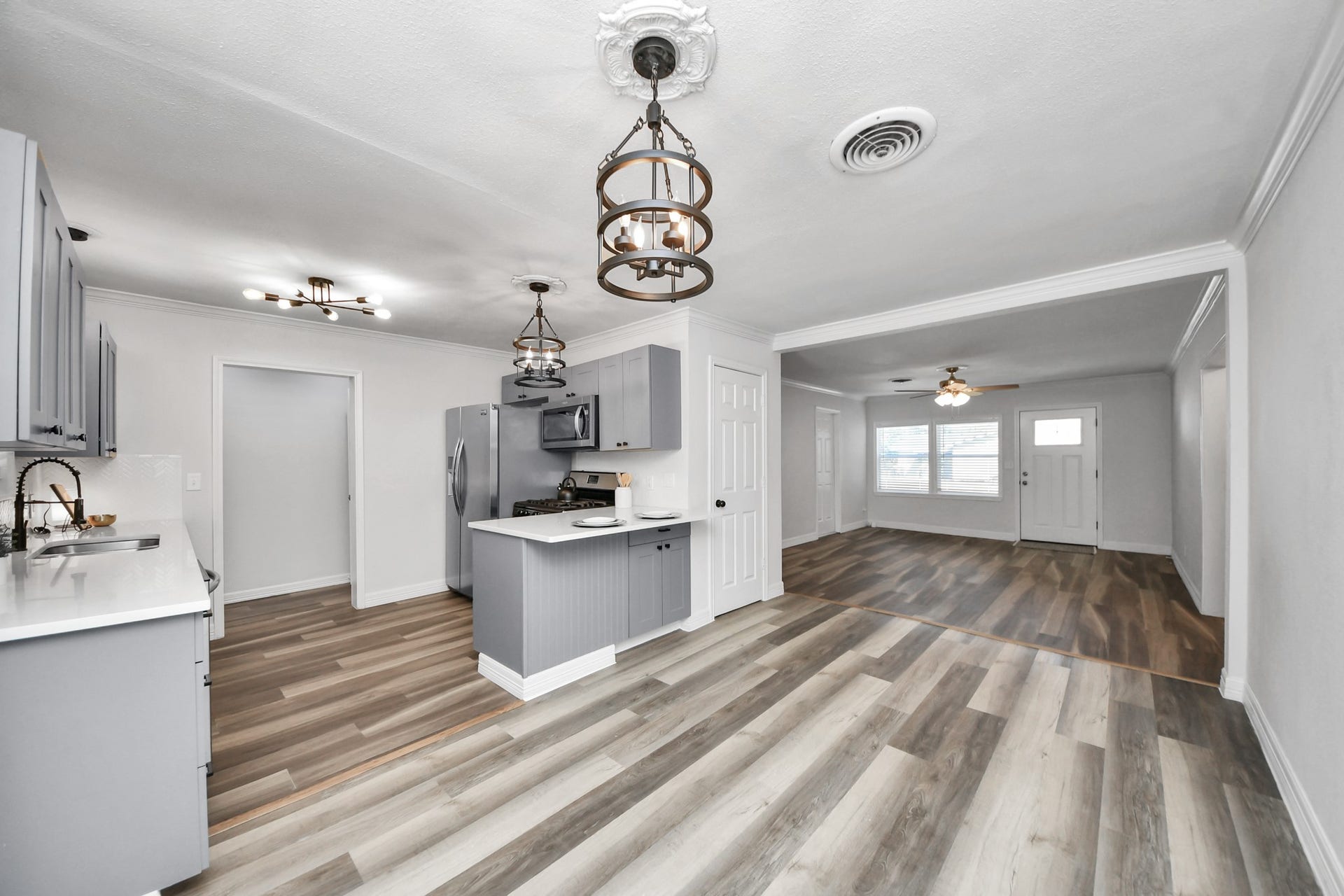 1309 W Lang Street, Alvin, TX 77511 Open Kitchen and Dining Area flowing into the Living Room with Wood-Look Laminate Flooring throughout.