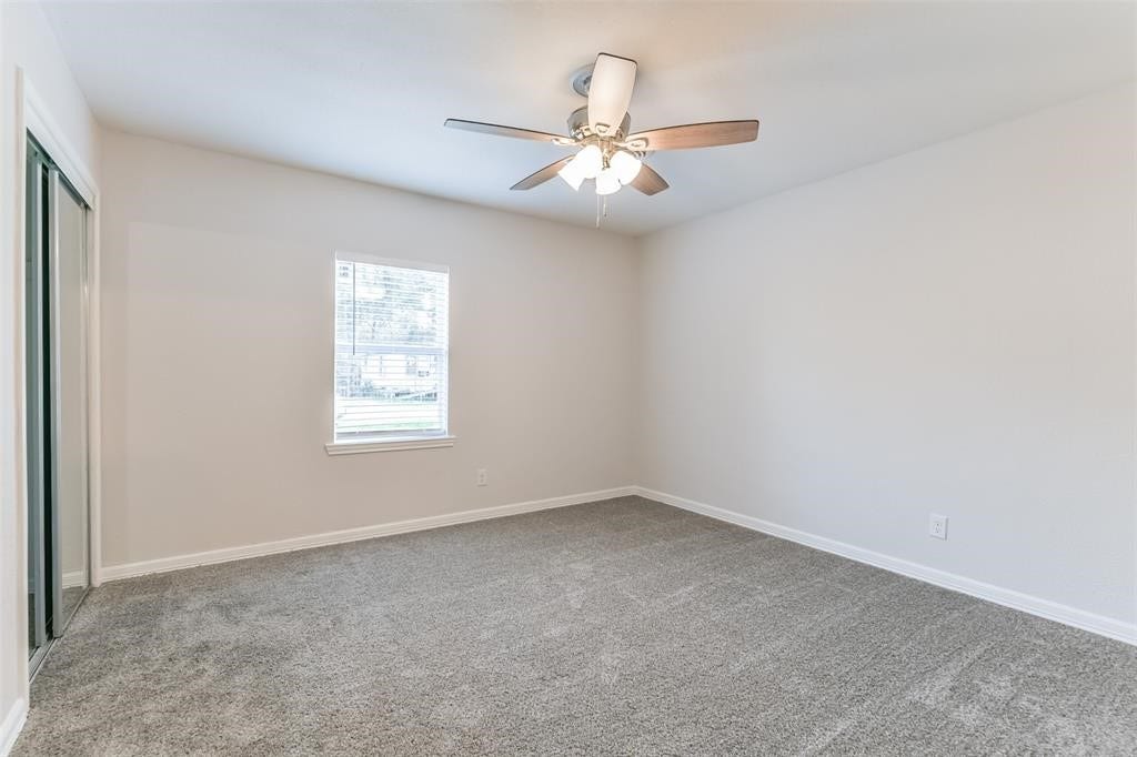 1309 W Lang Street, Alvin, TX 77511 Bedroom 2 with sliding mirrored closet doors and Front Yard View