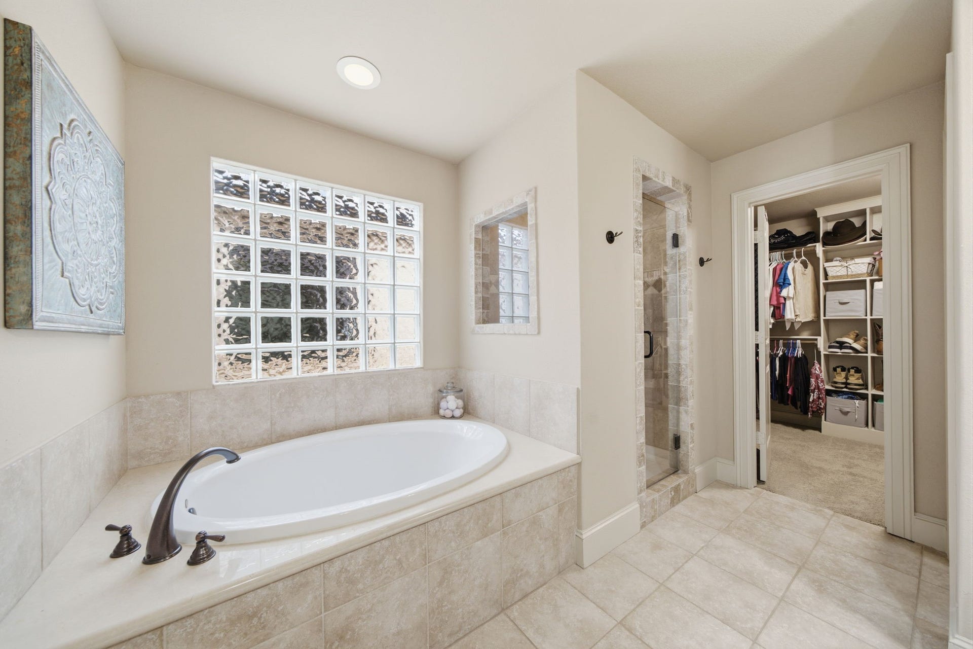 Luxurious soaking tub with glass block tiles offering light but full privacy.
