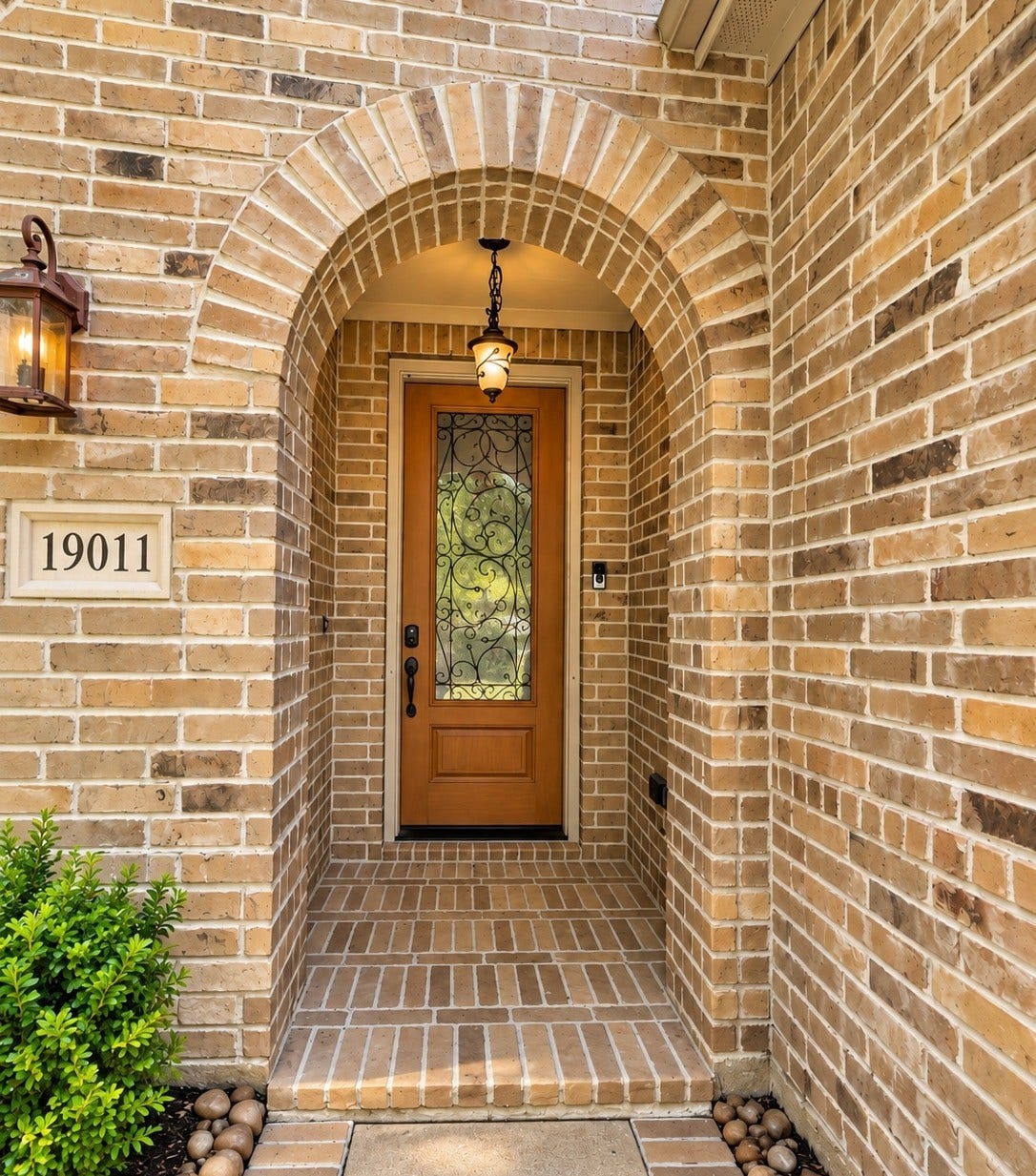 19011 Crest Cove Drive, Cypress, TX 77433 A wood front door with decorative glass and a pendant light give the home a warm, welcoming first impression.