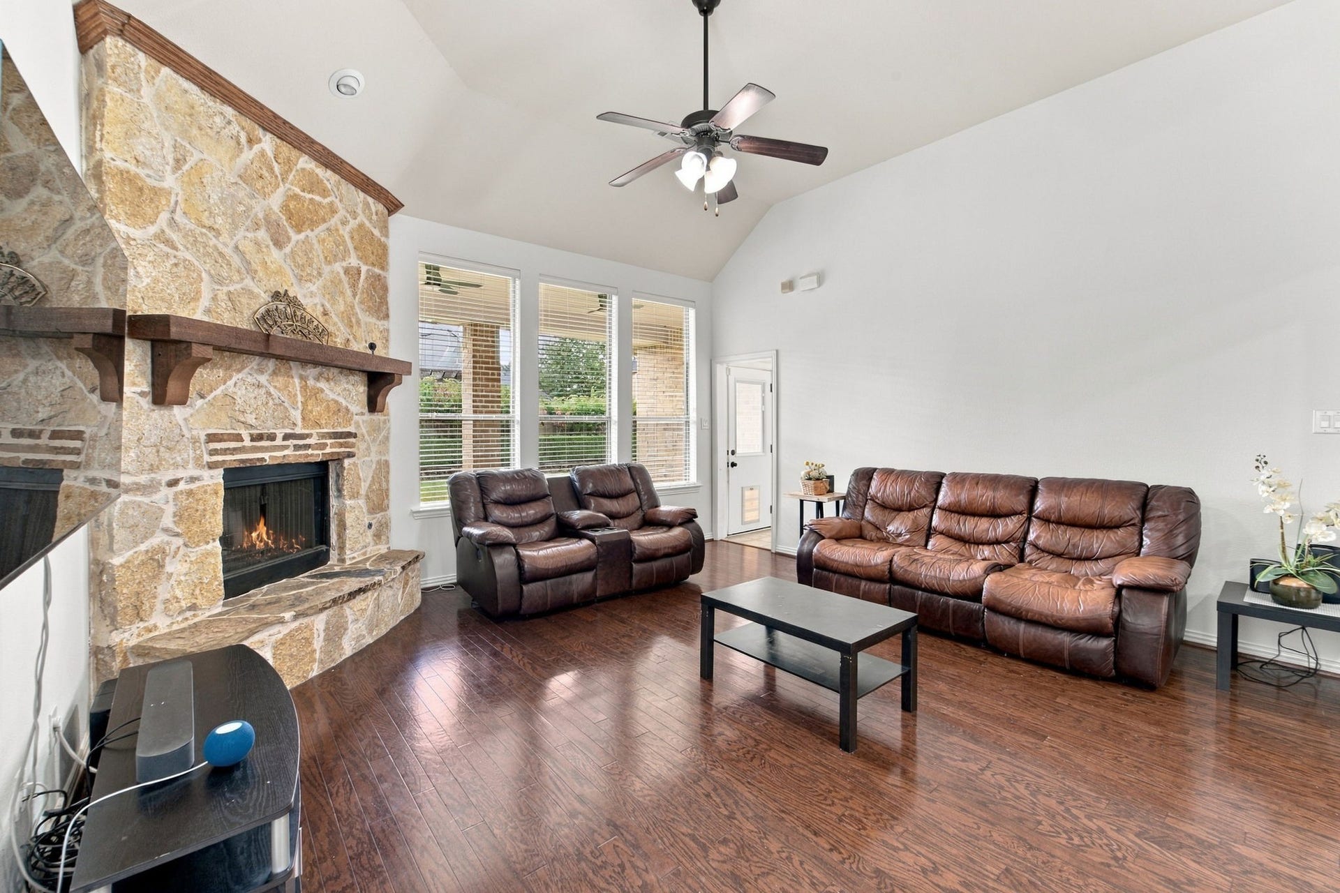 19011 Crest Cove Drive, Cypress, TX 77433 The spacious living room is made for gathering, with a stone fireplace and wood mantel as the focal point.