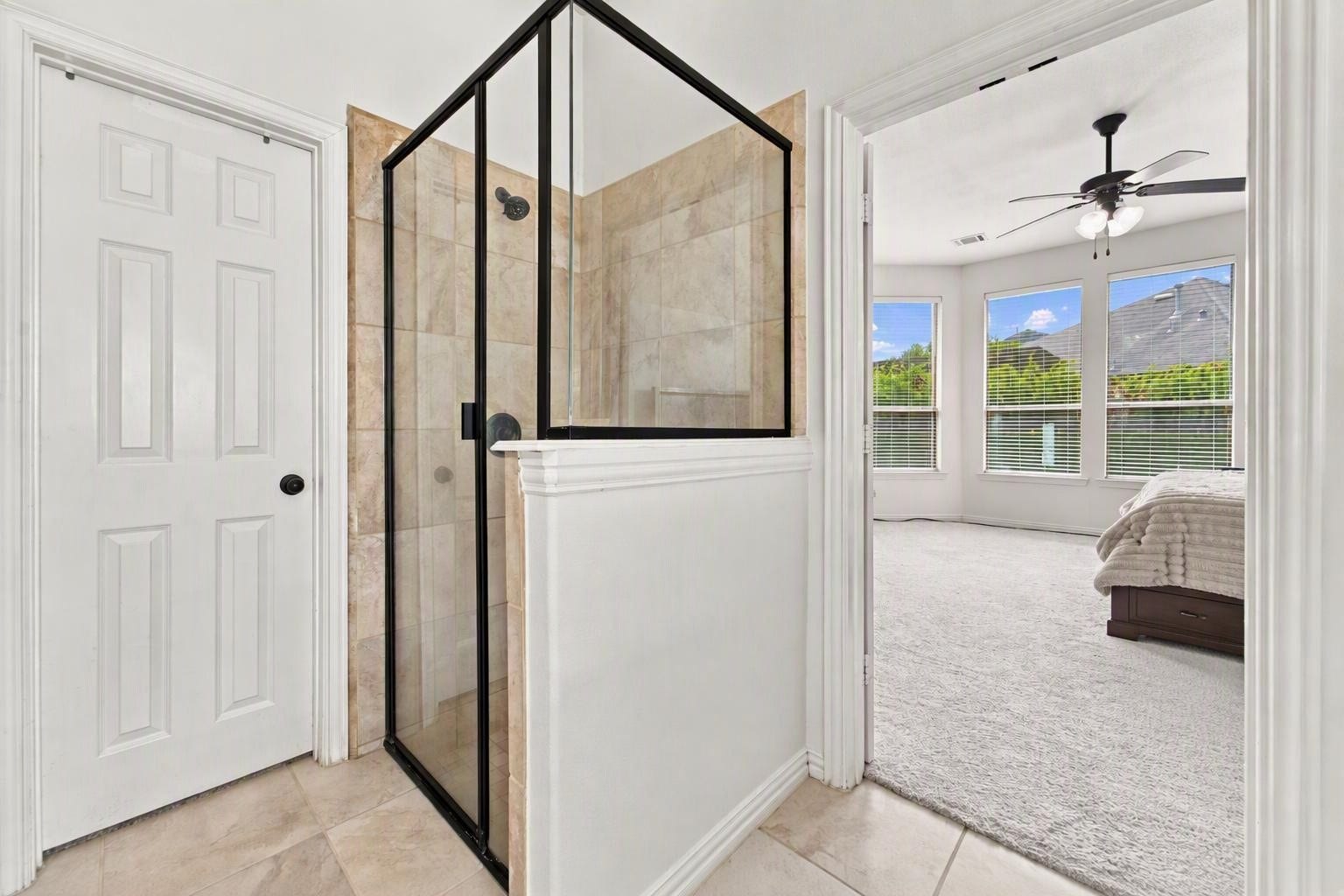 19011 Crest Cove Drive, Cypress, TX 77433 The walk-in shower of the primary bathroom, with tile surround and glass enclosure.