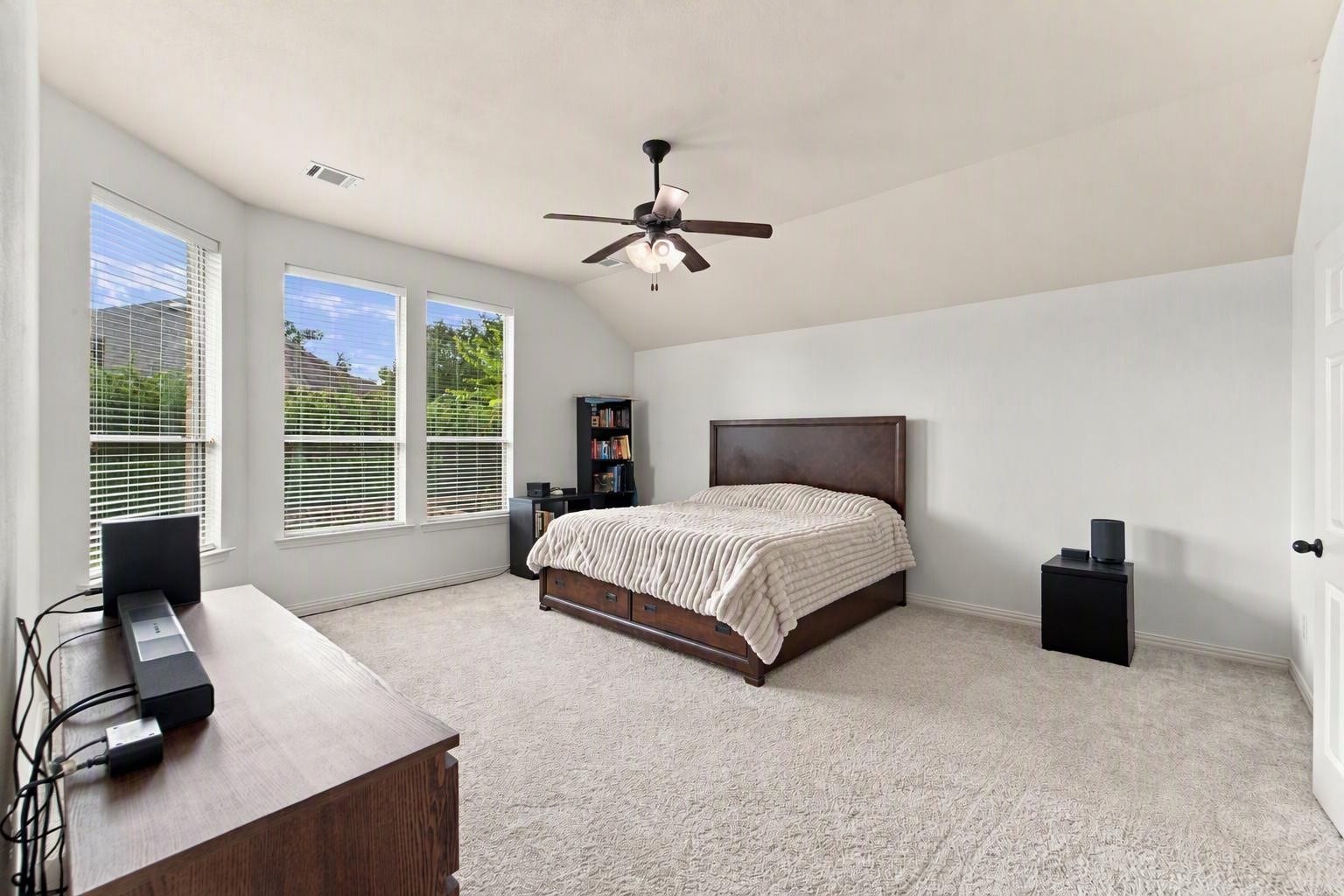 19011 Crest Cove Drive, Cypress, TX 77433 This generously sized primary bedroom is a comfortable place to start and end your day. Soft carpet, a ceiling fan, and a wall of windows bring in plenty of natural light. Edited using AI tools.