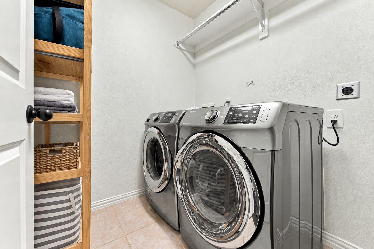 19011 Crest Cove Drive, Cypress, TX 77433 A practical laundry room with space for a full-size washer and dryer, plus a hanging rod for added convenience.