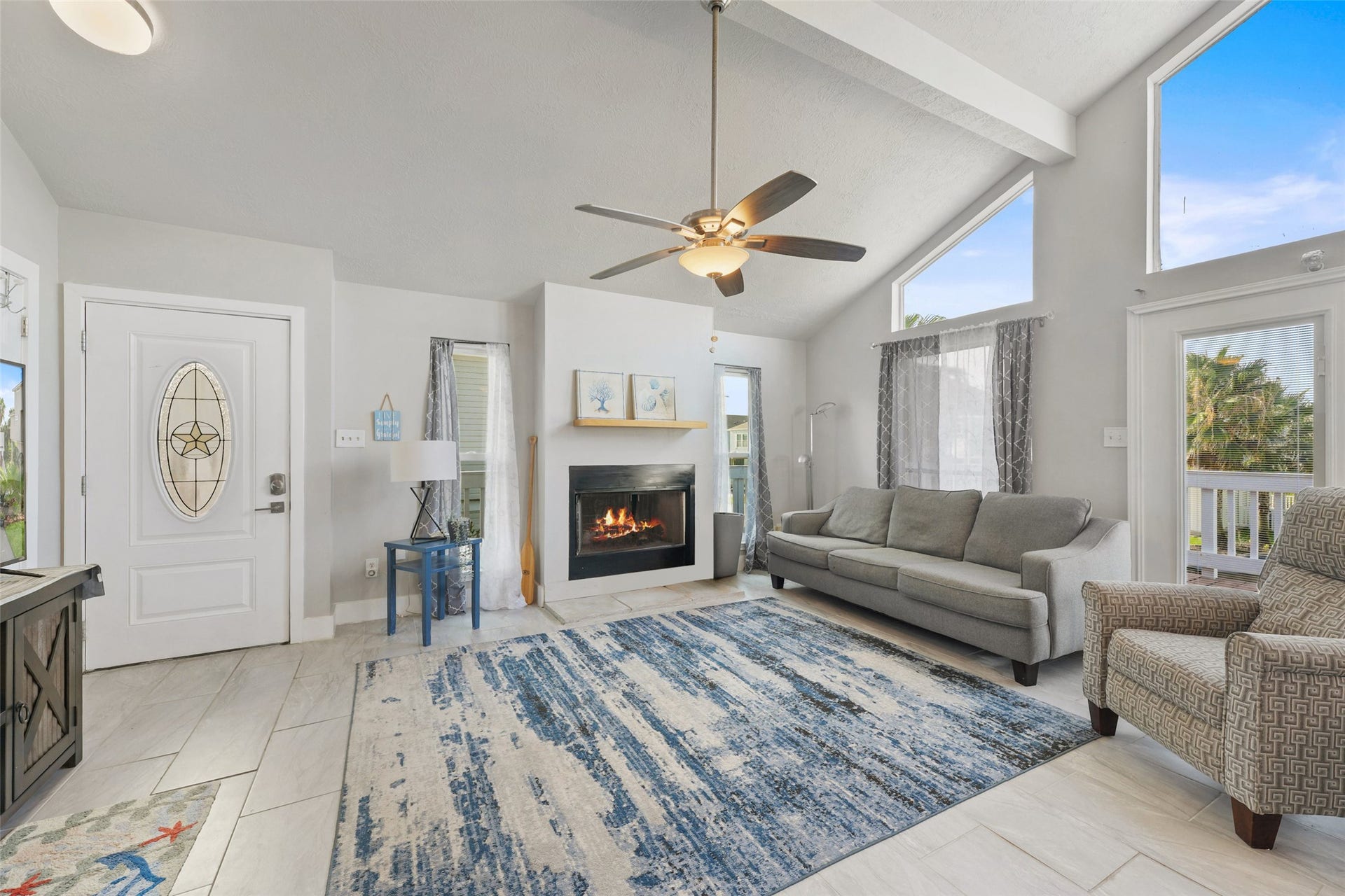 22513 Bay Point Drive, Galveston, TX 77554 The welcoming living room features tile flooring, a
ceiling fan, high ceilings, cozy fireplace, and a wall
of windows.