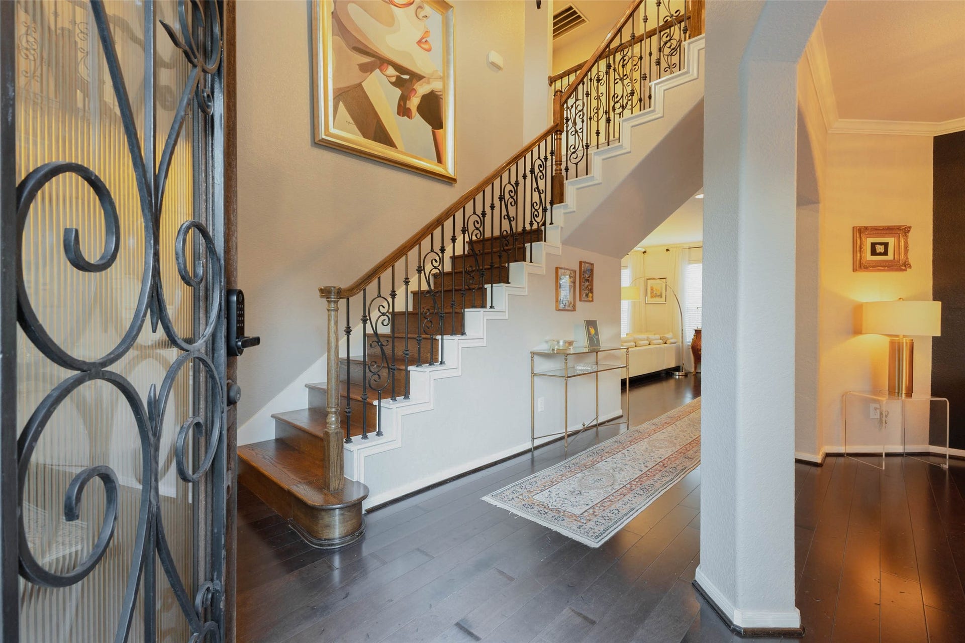 25734 Jewel Springs Lane, Katy, TX 77494 Rich hardwood flooring, intricate wrought-iron detailing, and a sweeping staircase introduce the home's distinctive character with a grand entry.