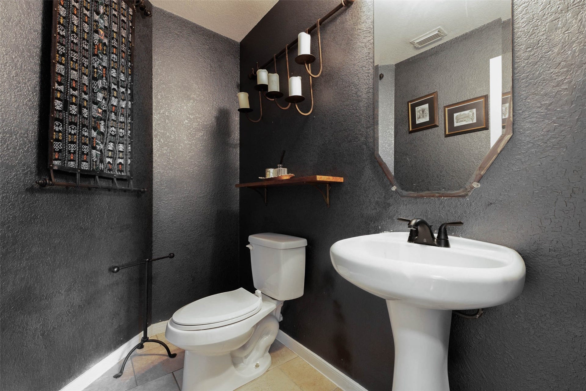 25734 Jewel Springs Lane, Katy, TX 77494 Moody charcoal walls, textured finishes, and sculptural lighting give this powder bath a boutique-inspired edge.