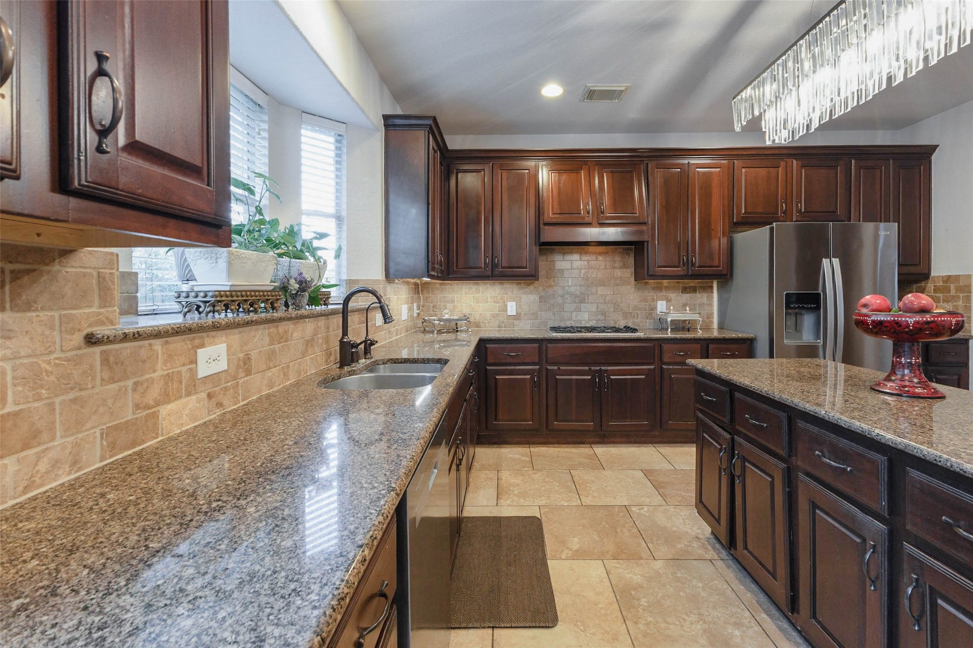 25734 Jewel Springs Lane, Katy, TX 77494 Generous preparation space with expansive granite work surfaces & a neutral stone backsplash in this kitchen.