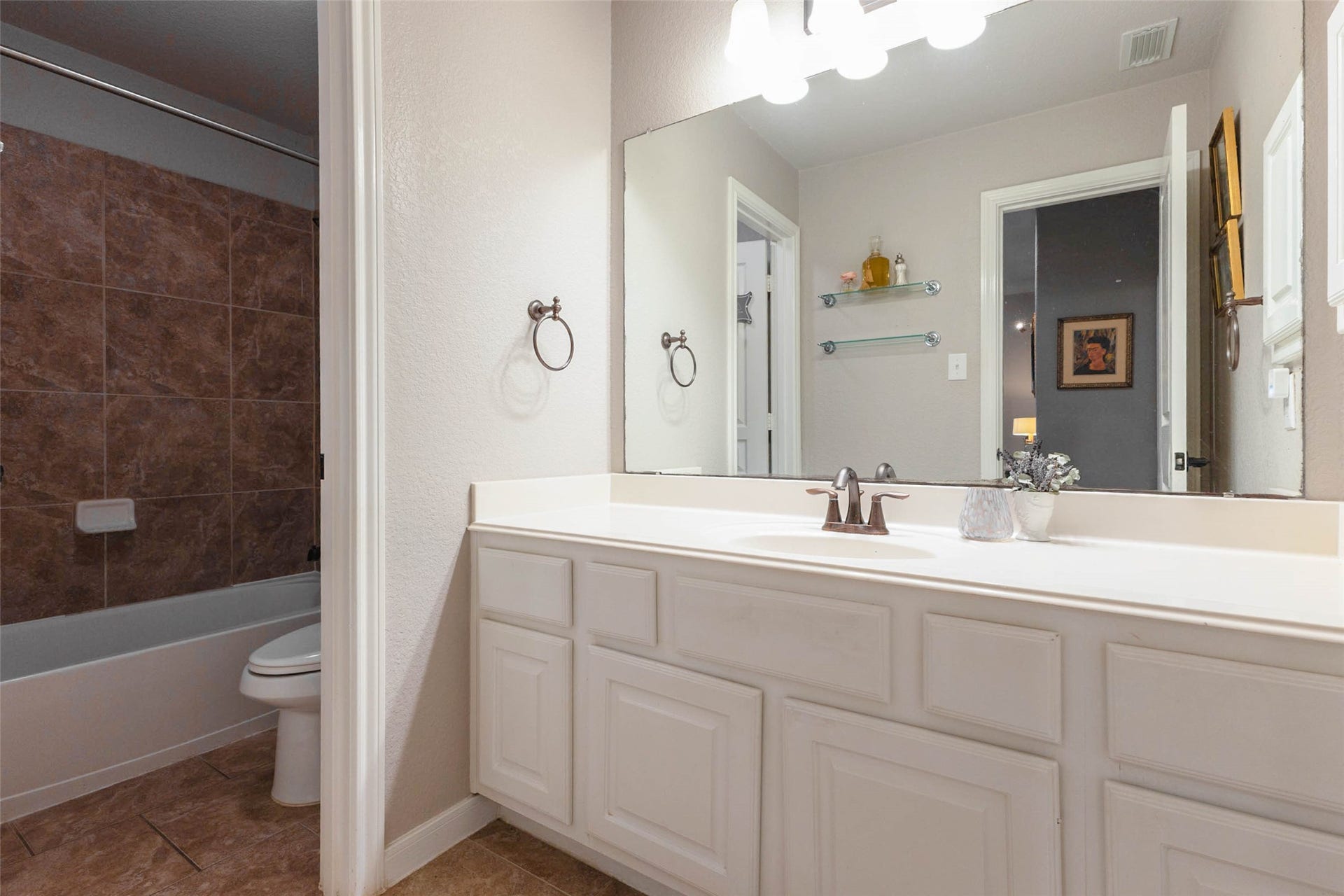 25734 Jewel Springs Lane, Katy, TX 77494 A well appointed secondary bathroom features a spacious vanity and a tiled tub-and-shower combination.