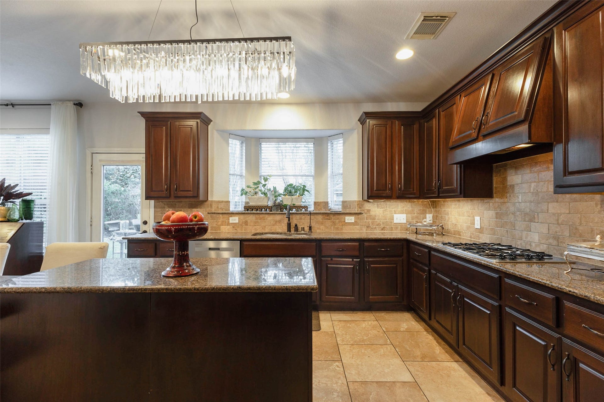 25734 Jewel Springs Lane, Katy, TX 77494 Granite countertops & richly stained cabinetry bring an elevated aesthetic to this well-appointed kitchen.