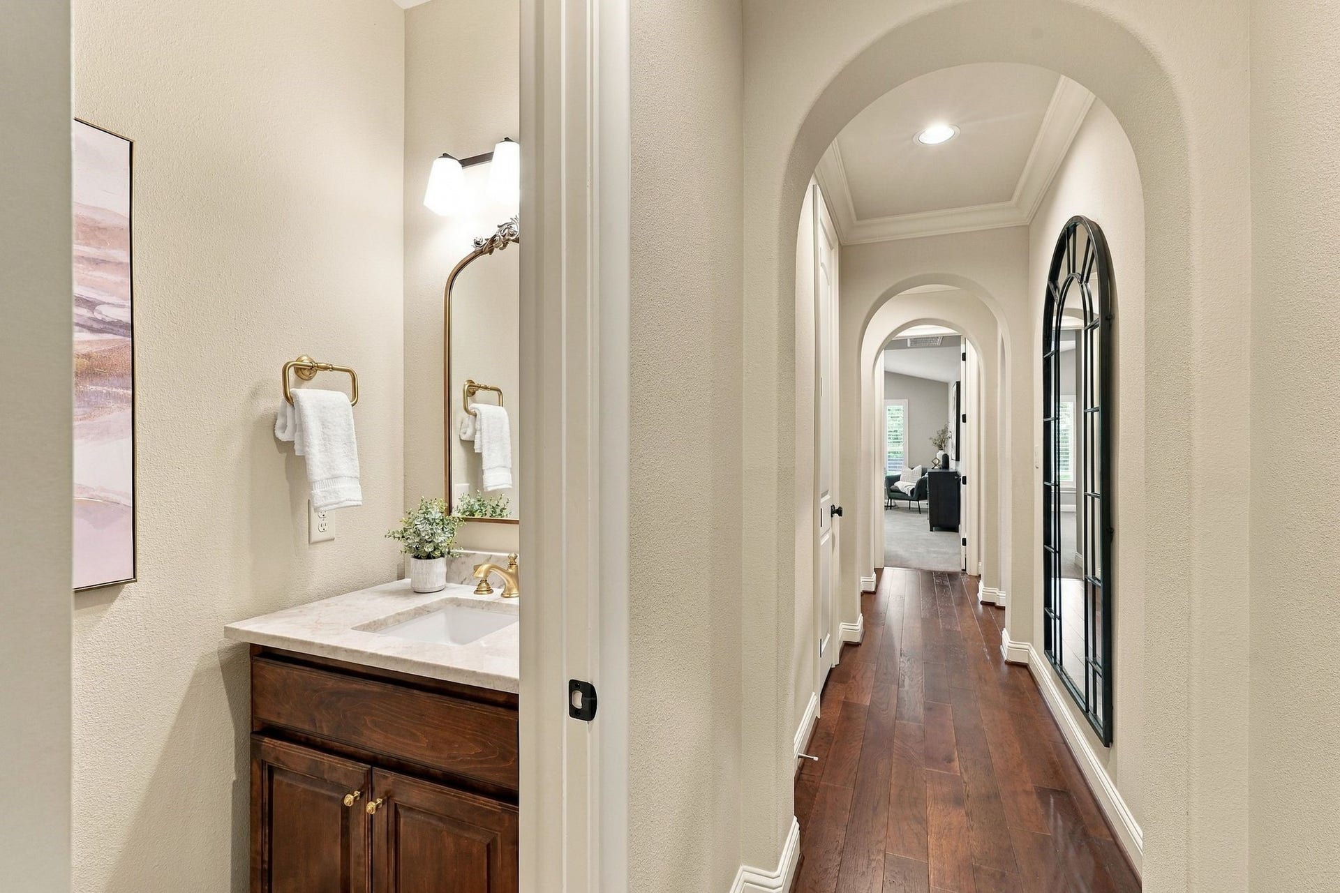 51 Woodglade Way, The Woodlands, TX 77375 The guest half bath has been updated with Taj Mahal quartzite, new lighting, mirror and sink fixtures.