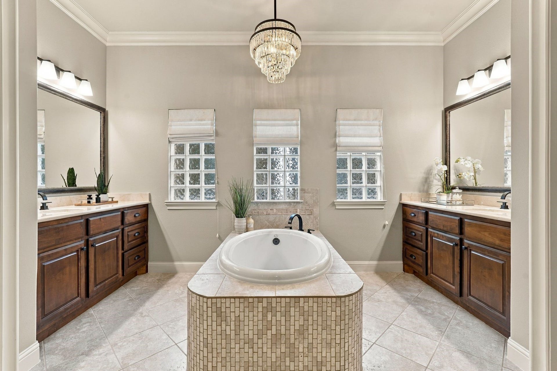 51 Woodglade Way, The Woodlands, TX 77375 Spa like bathroom with double sinks, tub, and elegant light fixture.