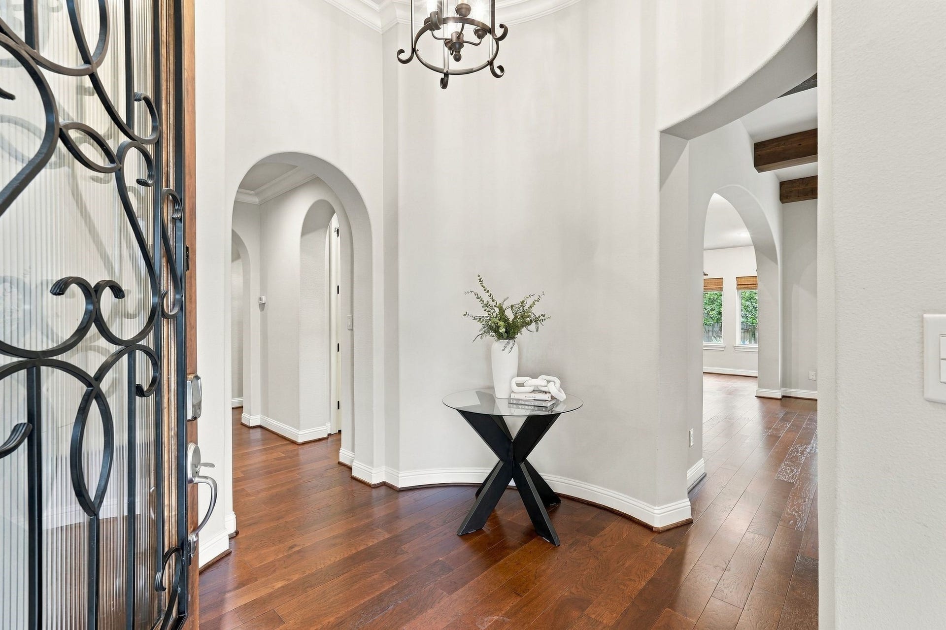 51 Woodglade Way, The Woodlands, TX 77375 Welcoming entry featuring rich hardwood floors, soaring ceilings, and graceful arched openings that add architectural character and create a beautiful flow throughout the home.
