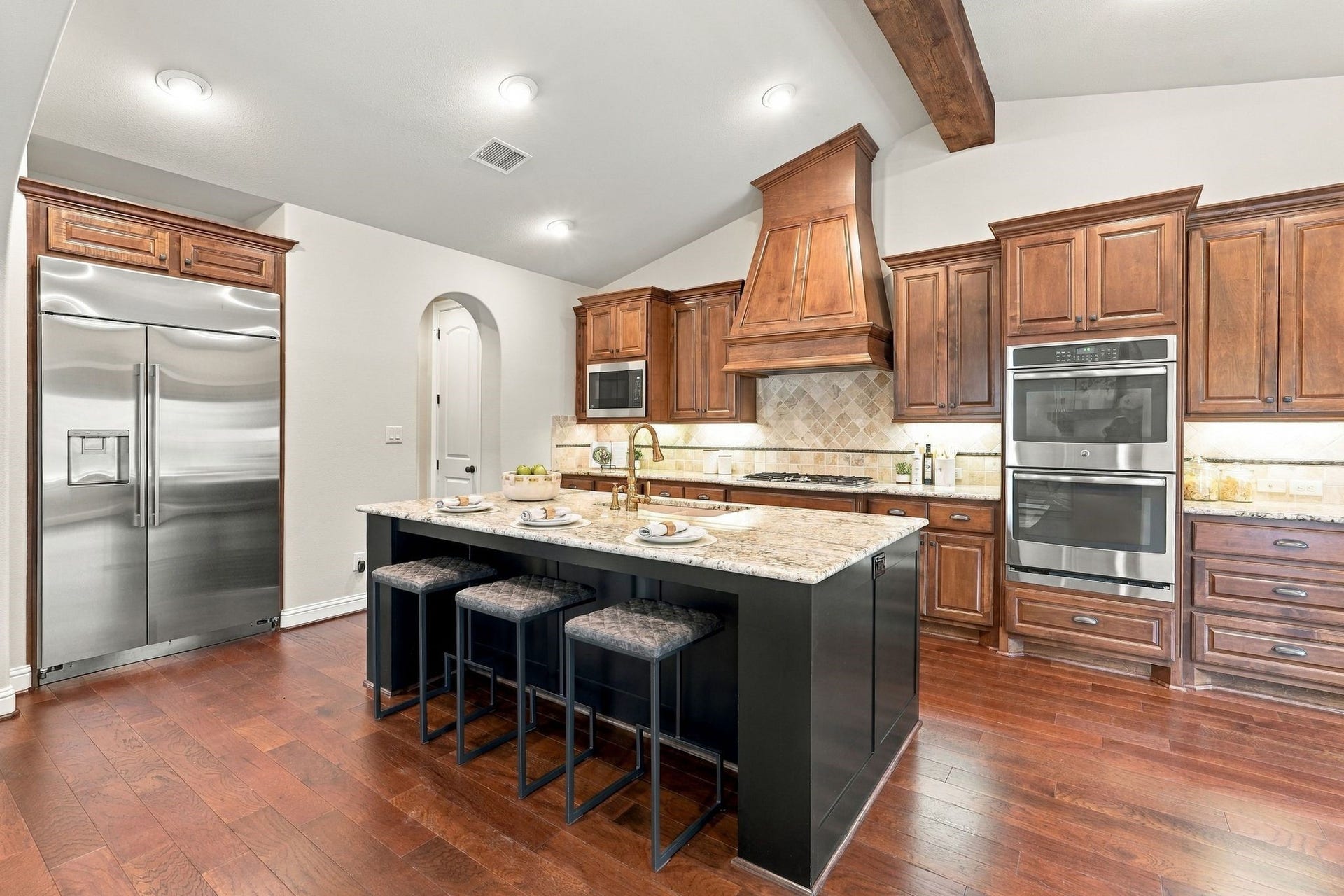 51 Woodglade Way, The Woodlands, TX 77375 Stainless steel appliances, built in refrigerator, double ovens, ample seating at the kitchen island.