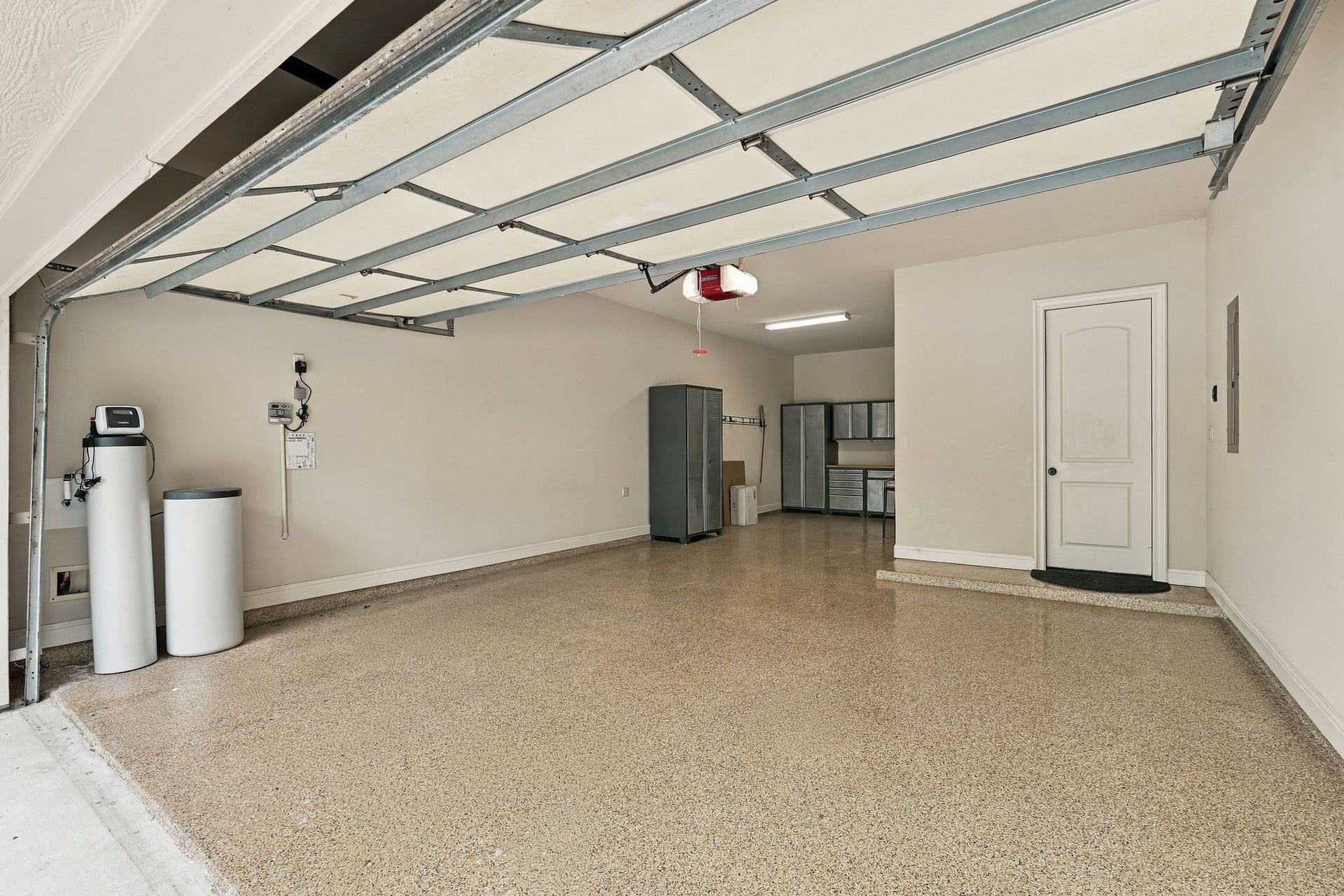 51 Woodglade Way, The Woodlands, TX 77375 Very clean three car garage with built in storage and epoxy flooring. To the left is the water filtration system.