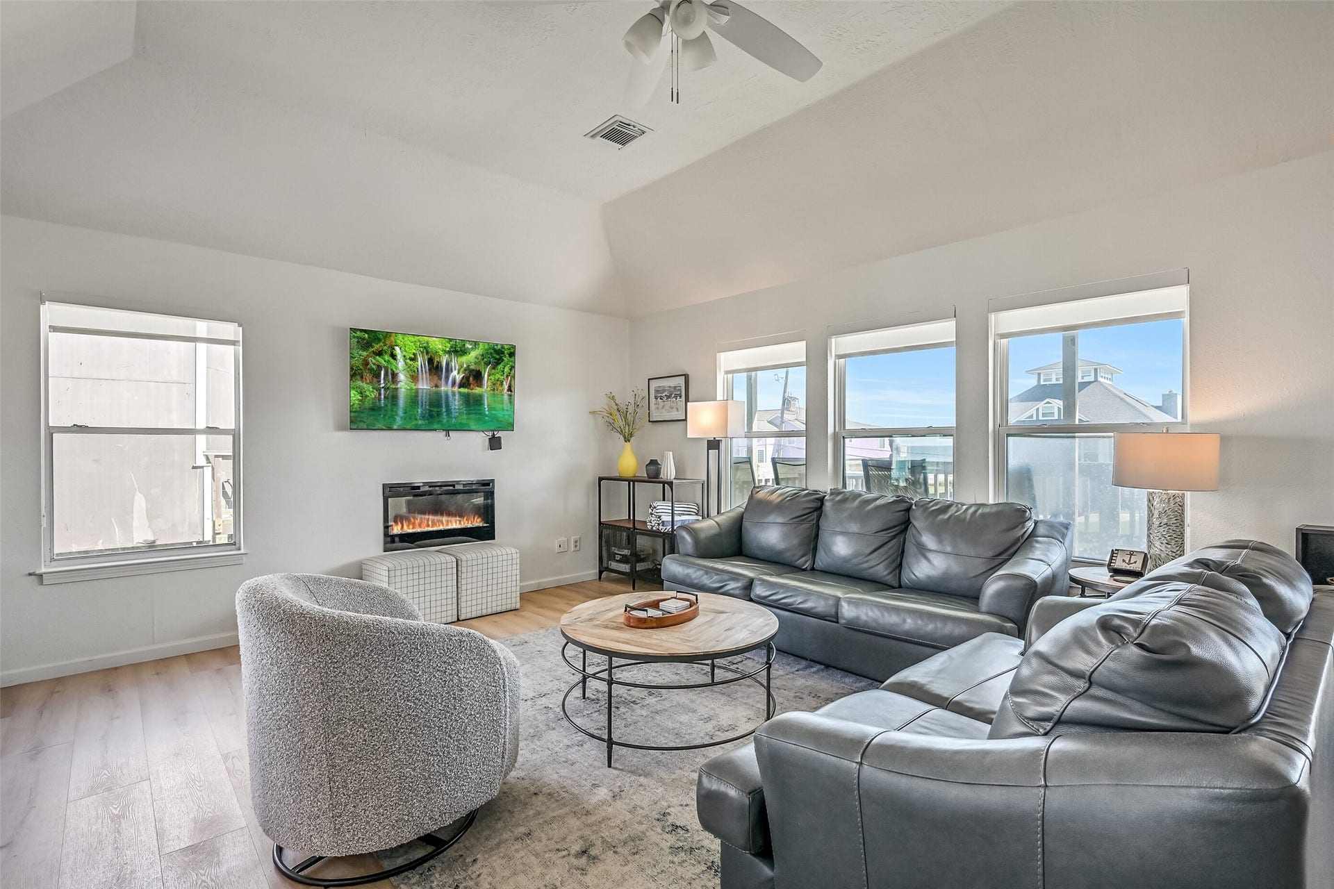 17620 Glei, Galveston, TX 77554 The spacious living room boasts walls of windows that fill the space with natural light, beautiful beach views, and an electric fireplace that adds a cozy touch.