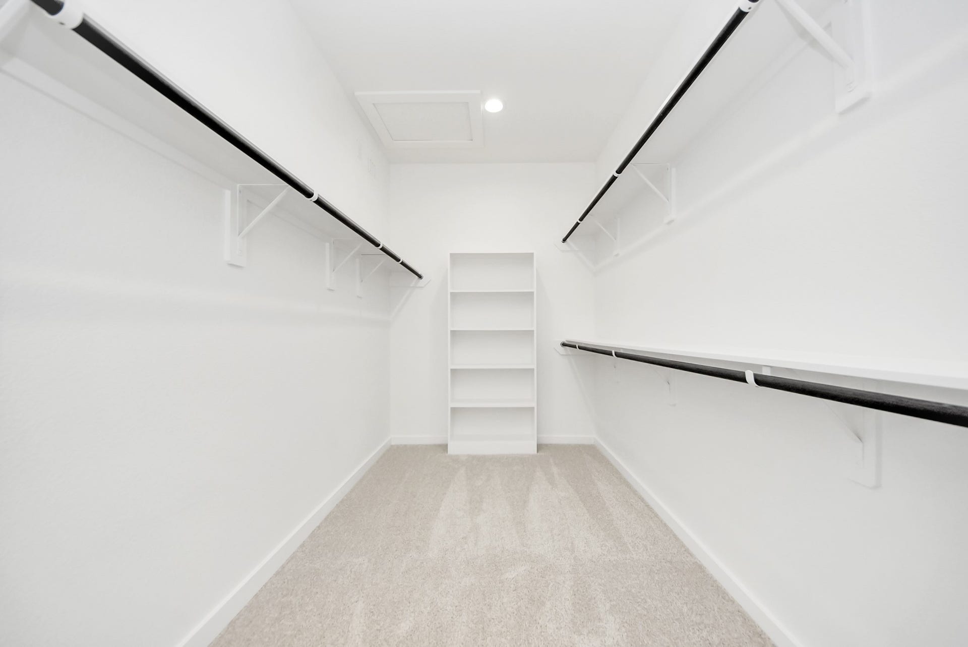 Walk-in closet that epitomizes luxury and practicality. This generously sized space features built-in shelving, offering abundant room for impeccable organization. High ceilings and recessed lighting create a bright and welcoming ambiance.