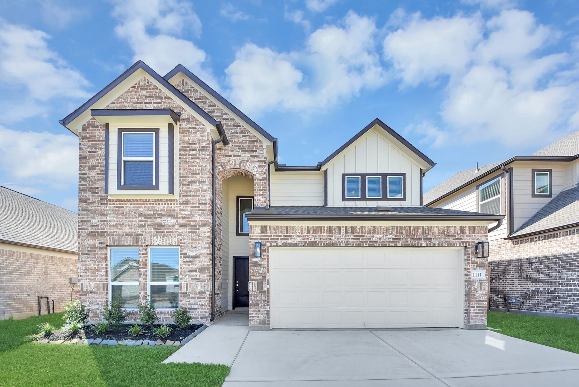 Meticulously maintained yard and lush landscape, paired with a premium elevation featuring captivating brick accents. Modern coach lights add a touch of contemporary elegance to the exterior.