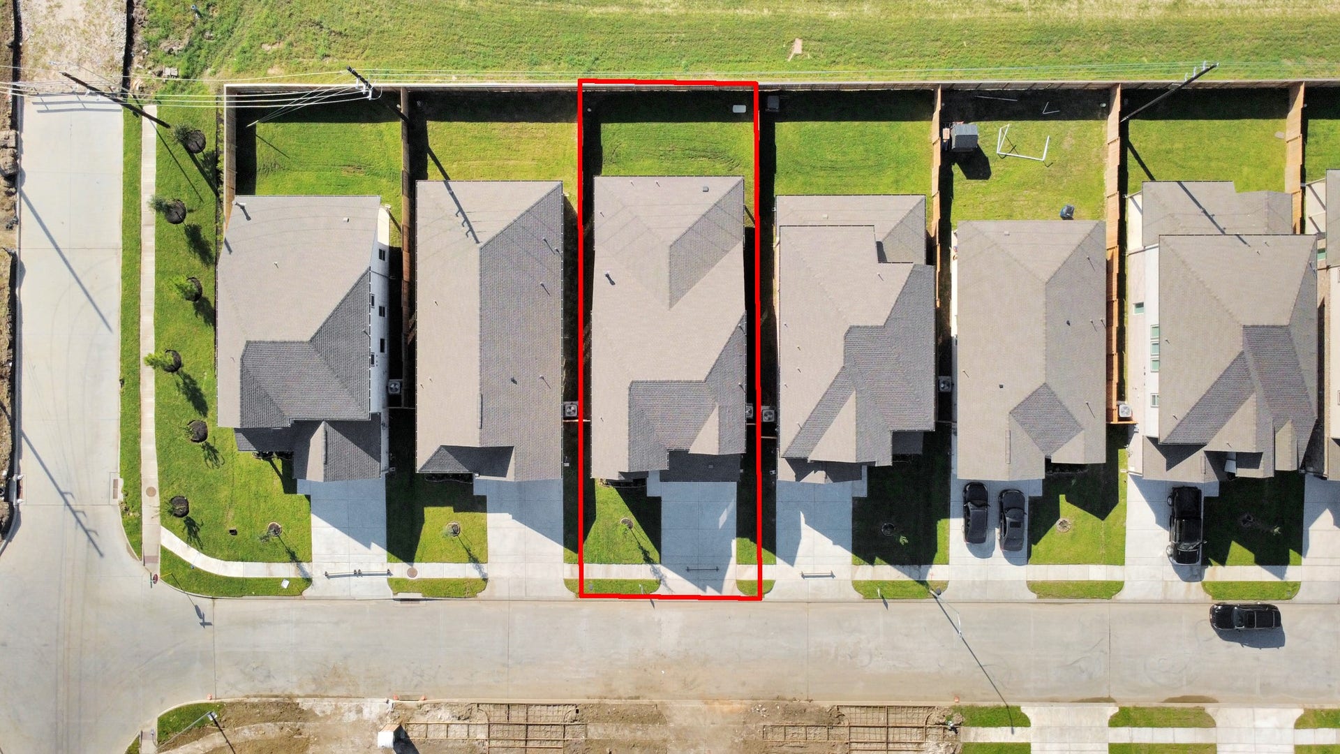 An aerial view of a spacious subdivision lot, highlighting a well-maintained yard and a fully fenced perimeter, offering both privacy and expansive outdoor space.