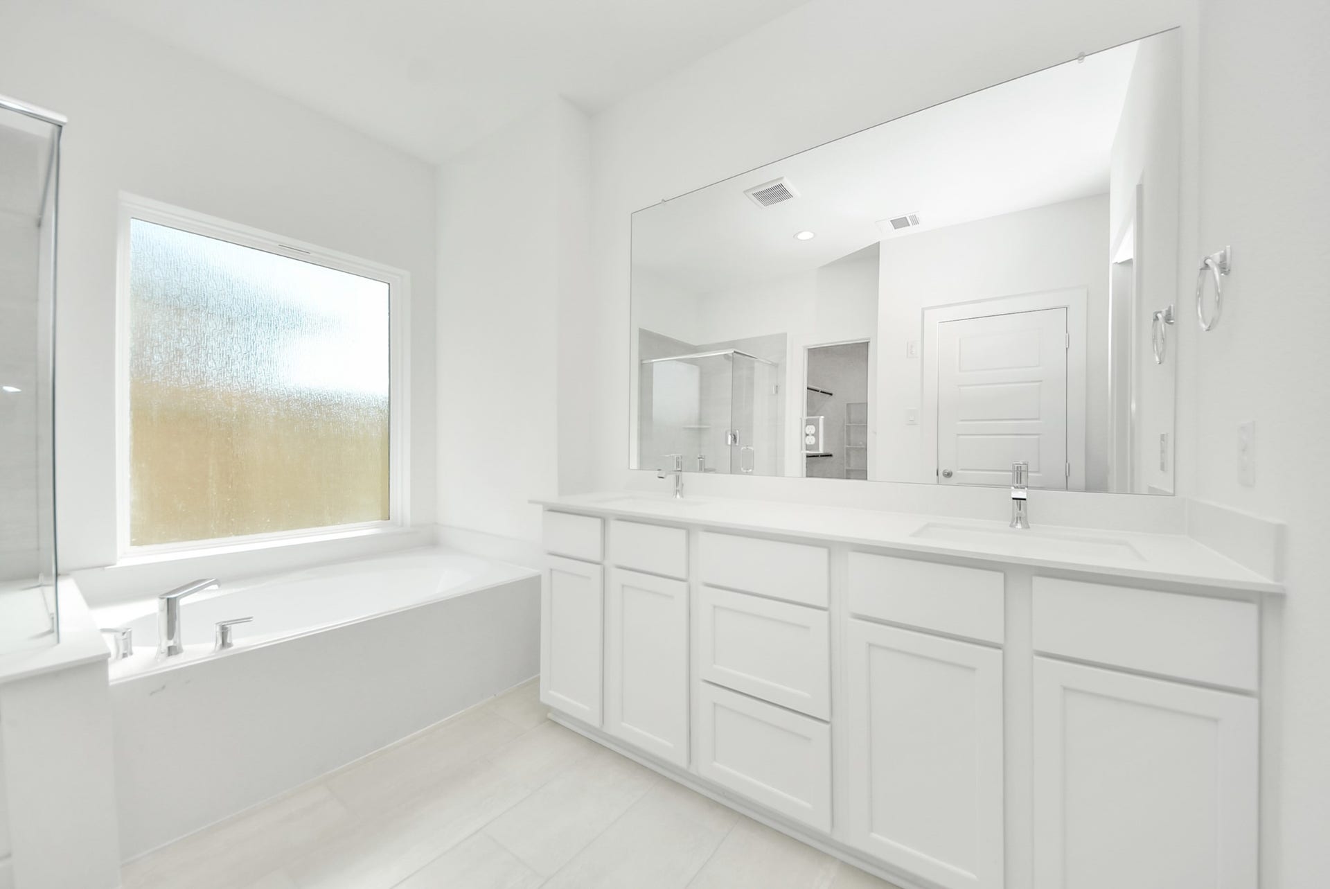 Elevate your daily routine at the elegant vanity, now equipped with double sinks, light countertops, modern hardware, and beautiful recessed lights.