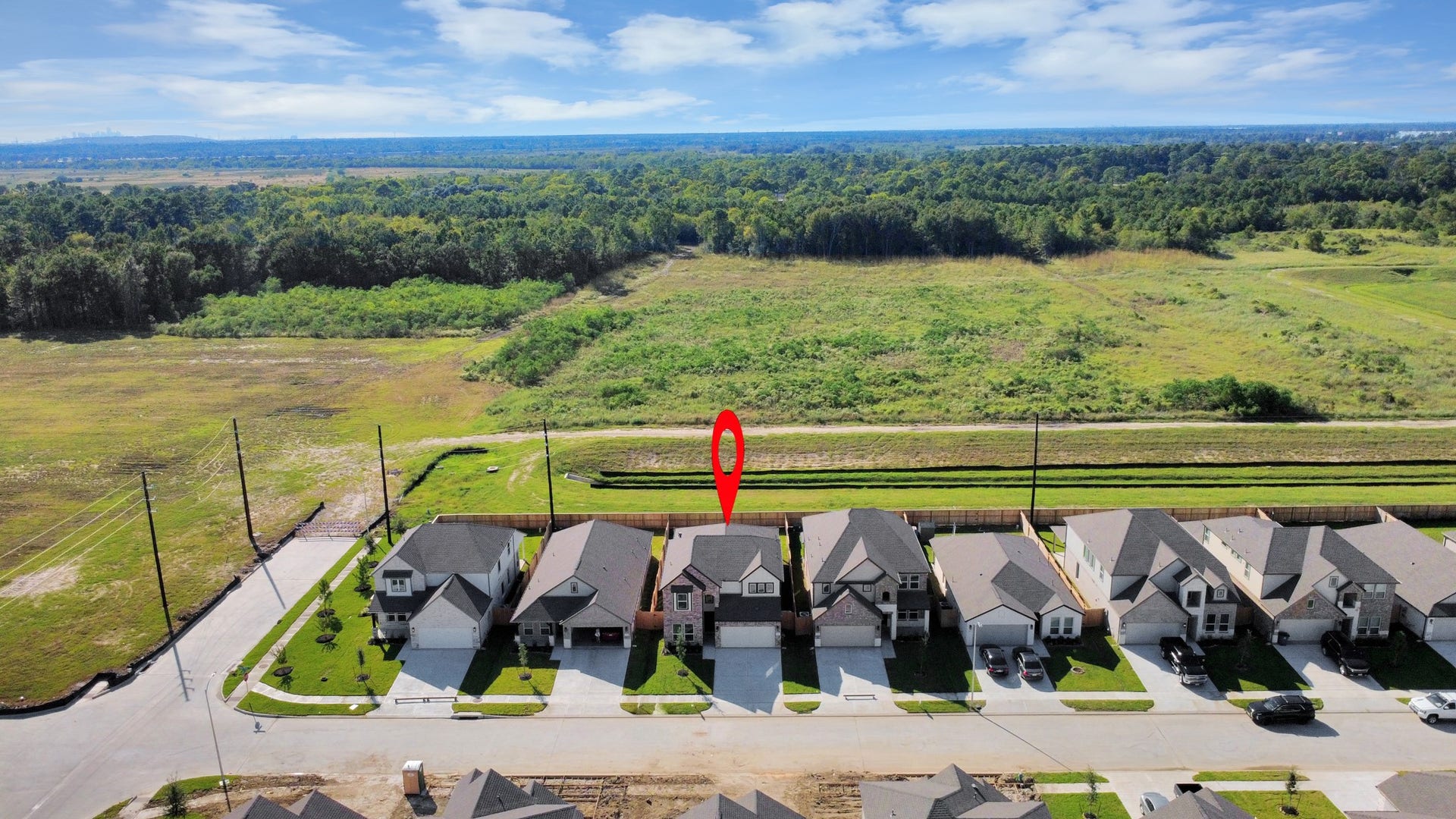 An aerial view of a spacious subdivision lot, highlighting a well-maintained yard and a fully fenced perimeter, offering both privacy and expansive outdoor space.