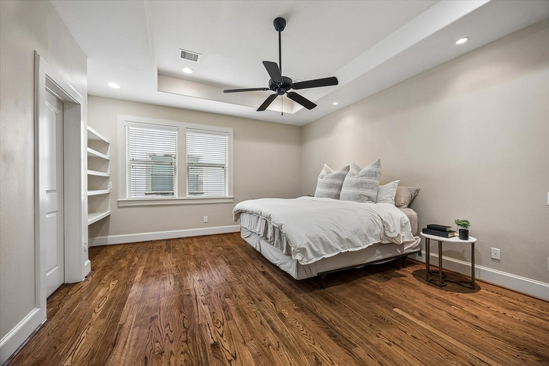 1112 Peveto Street, #C, Houston, TX 77019 The primary bedroom features built-in shelving, a large window, and lovely recessed ceiling.