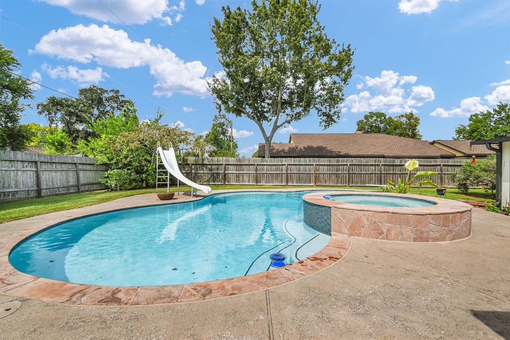 131 Frostwood Drive, Lake Jackson, TX 77566 Large pool with spa, slide and a diving board.