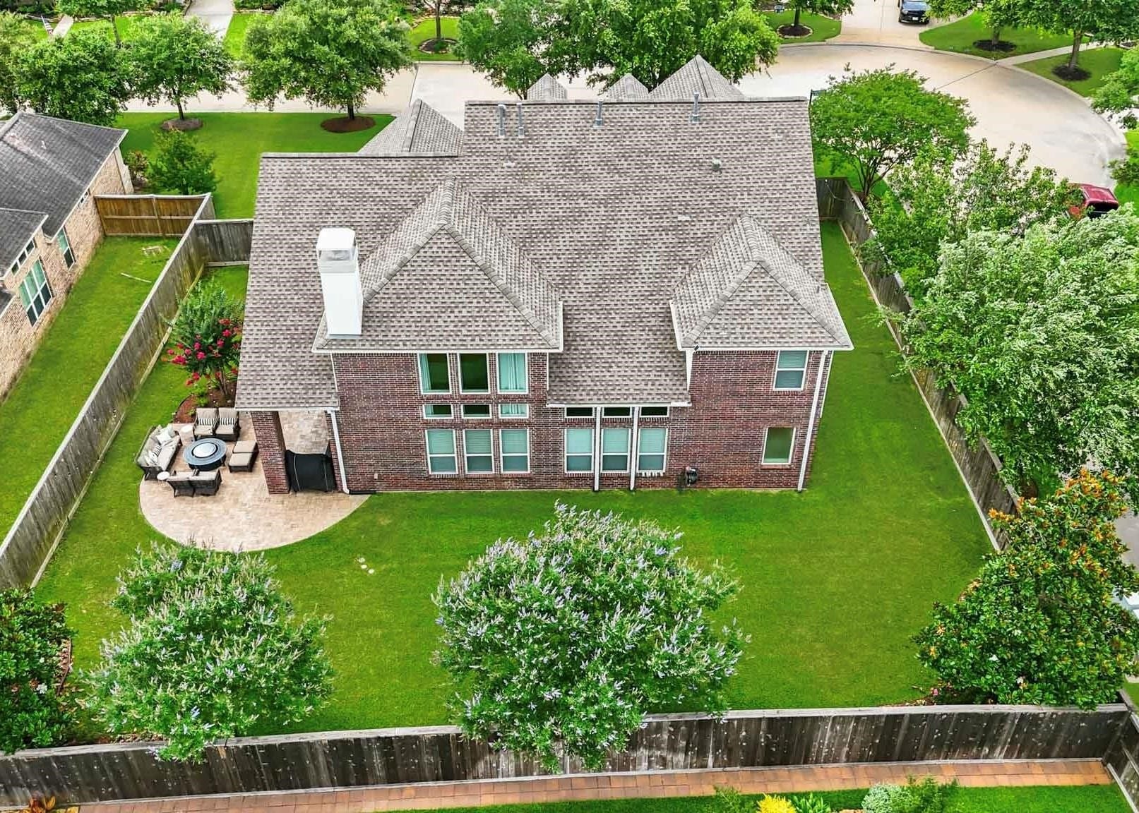 17610 Strackfield Lane, Tomball, TX 77377 A birds-eye view reveals one of the homes most impressive features: a resort-inspired backyard with lush green space, mature landscaping, and a spacious paver patio ideal for dining, relaxing, and enjoying the outdoors year-round.