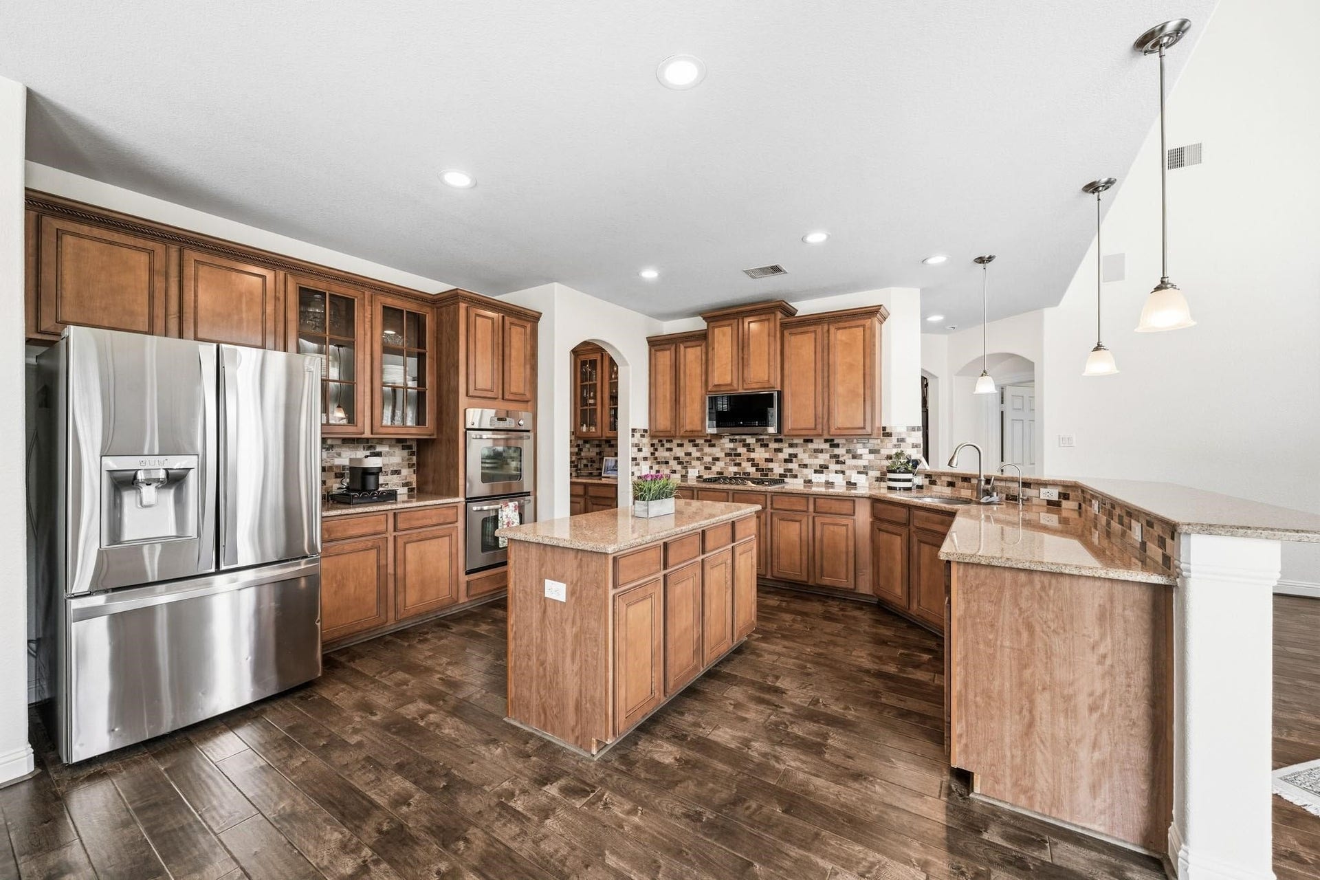17610 Strackfield Lane, Tomball, TX 77377 The island litchen provides a suite of premium appliances includes a five-burner gas cooktop, double ovens, microwave and the refrigerator stays with the home, while the coffee bar with granite counters and glass-front display cabinets add both function and sophistication.