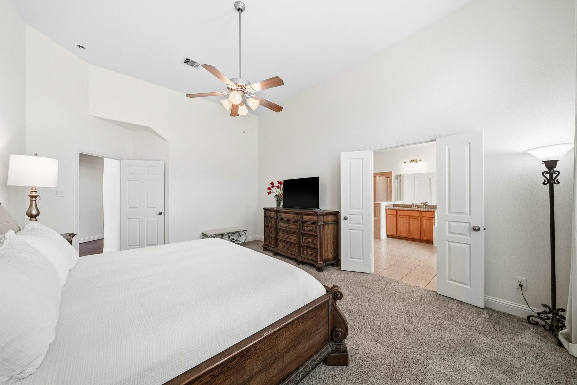 17610 Strackfield Lane, Tomball, TX 77377 Another view of the primary suite showcased the double-door entry to the primary bath and the ceiling fan with integrated lights create a serene retreat tailored to your comfort at any hour.