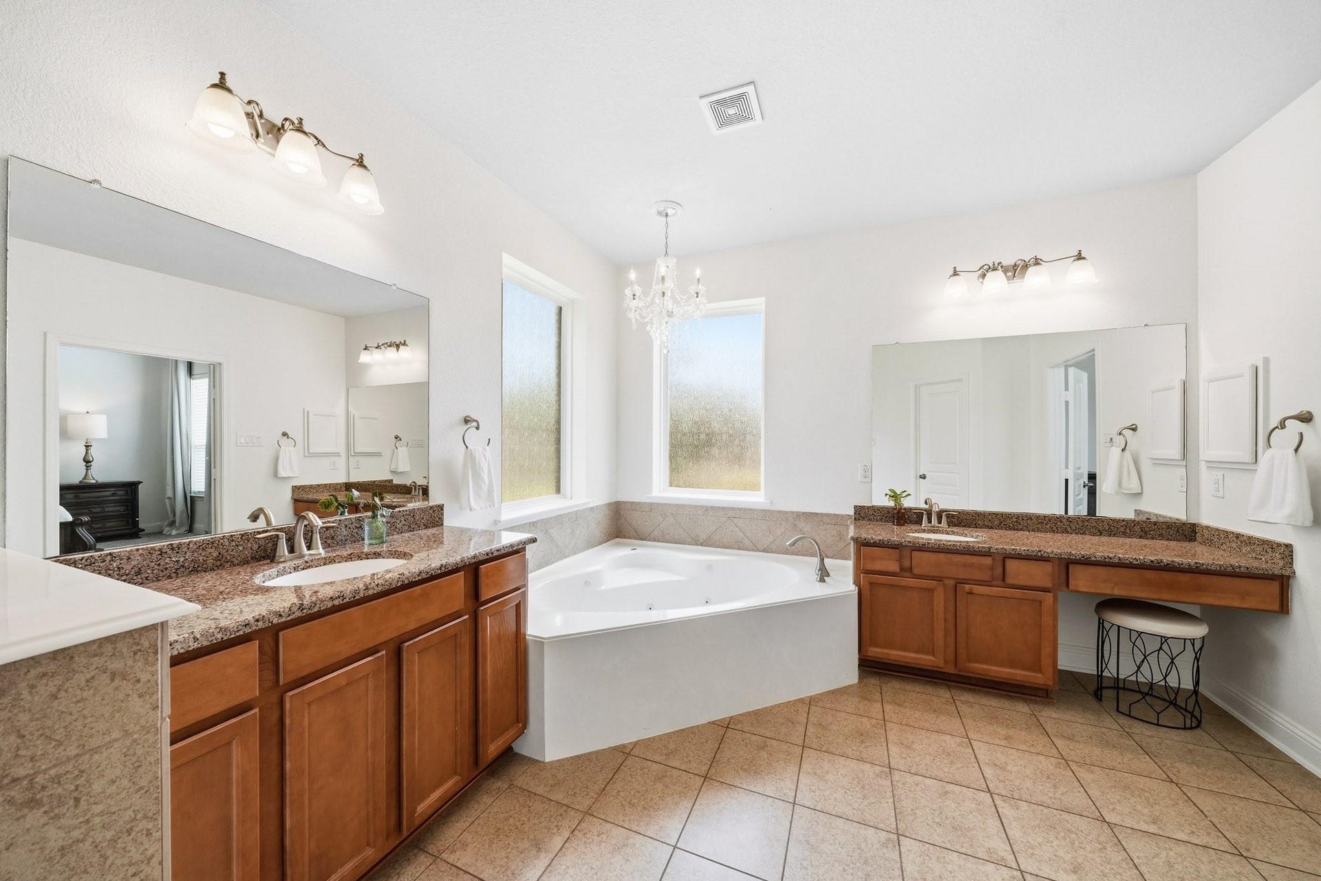 17610 Strackfield Lane, Tomball, TX 77377 A six-foot jetted tub serves as the centerpiece of the bathroom, perfectly positioned beneath dual rain-glass picture windows and illuminated by a sparkling chandelier, creating a spa-inspired retreat.