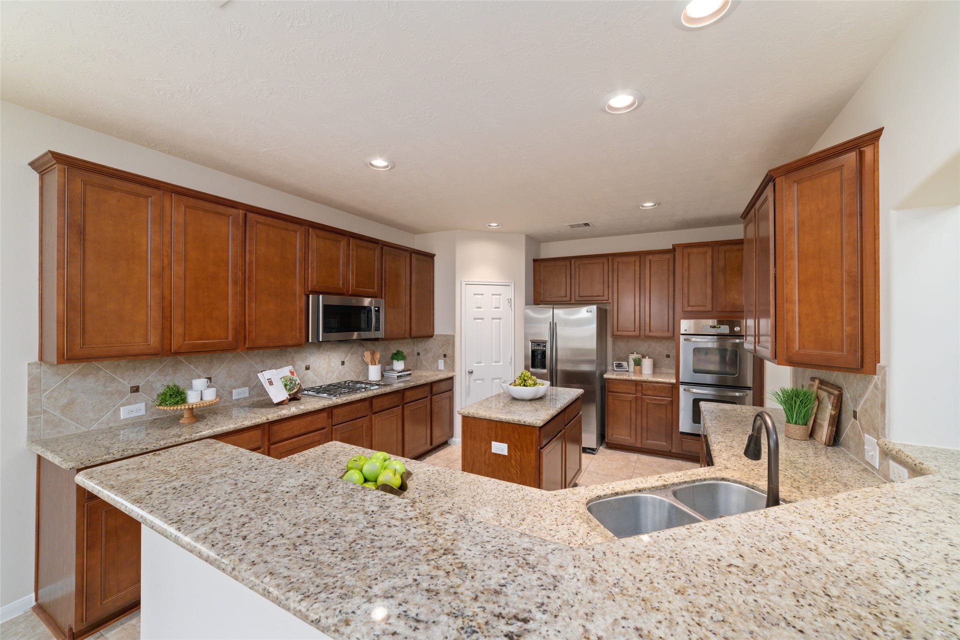 14422 Lakepointe Bend Lane, Cypress, TX 77429 Expansive kitchen with breakfast bar, stainless steel appliances and double ovens perfect for everything from casual breakfasts to entertaining a crowd