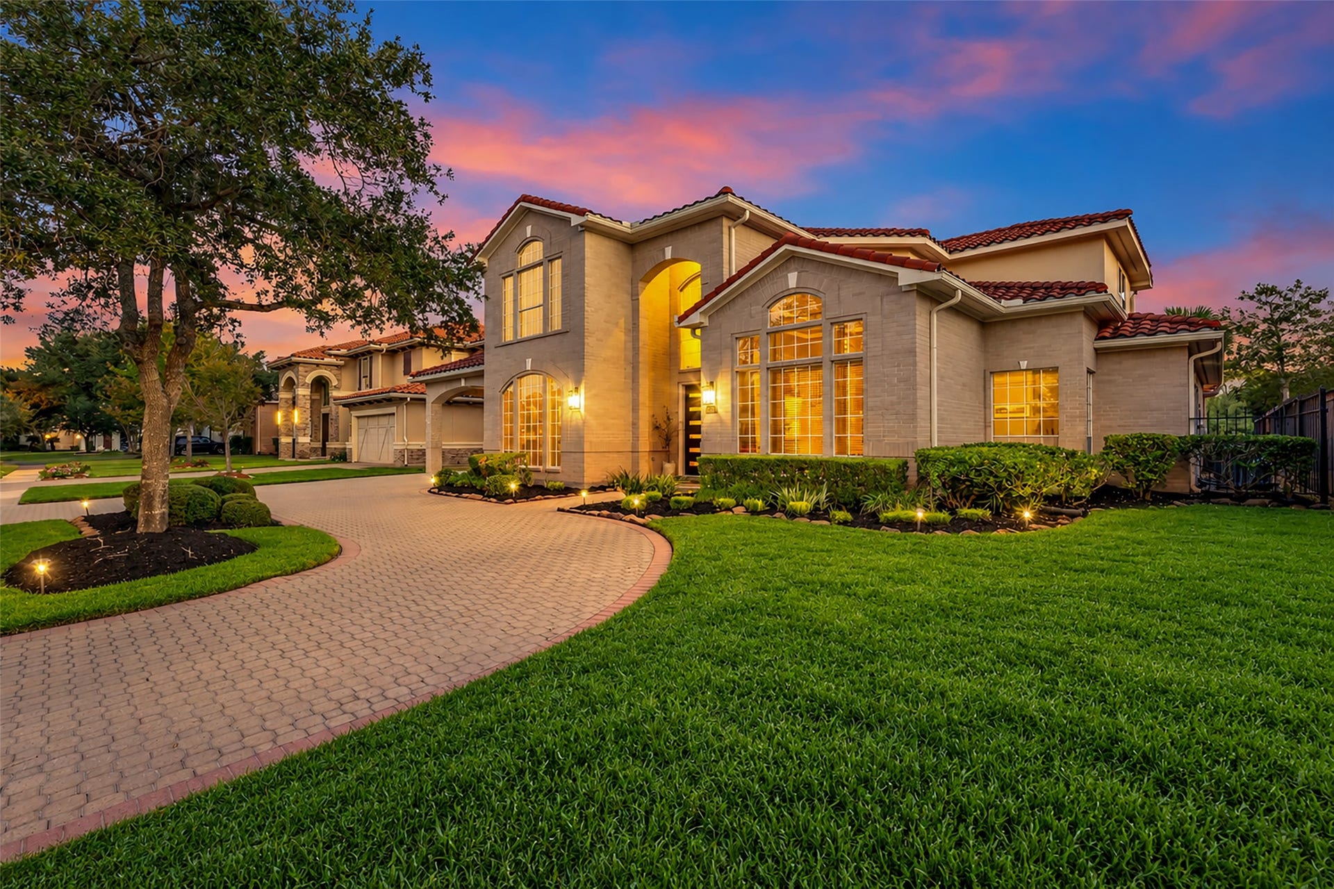 19023 Windsor Lakes Drive, Houston, TX 77094 The circular paver driveway leads to the porte-cochre and a modern glass garage door.
