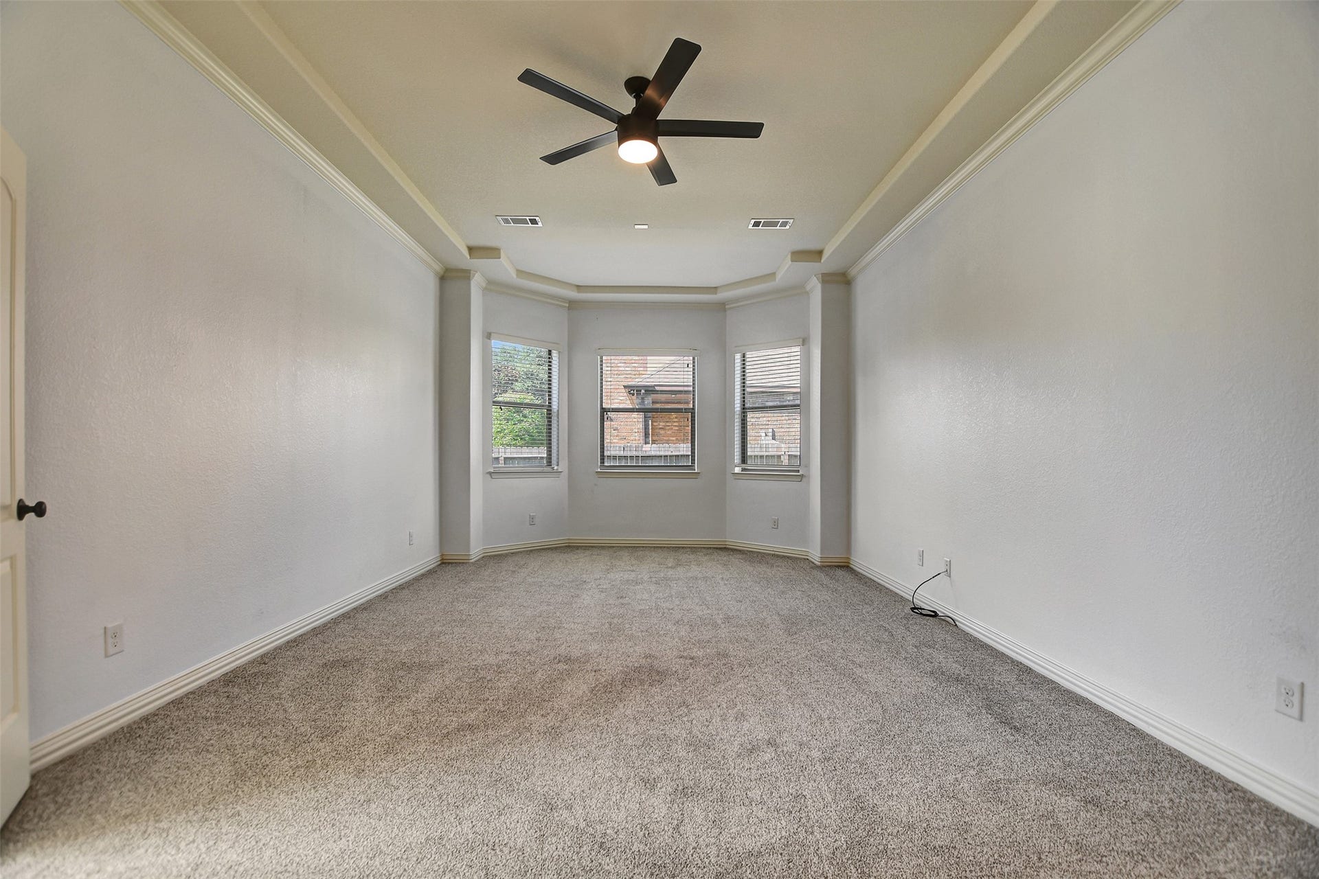 Large and spacious primary bedroom with new carpet.