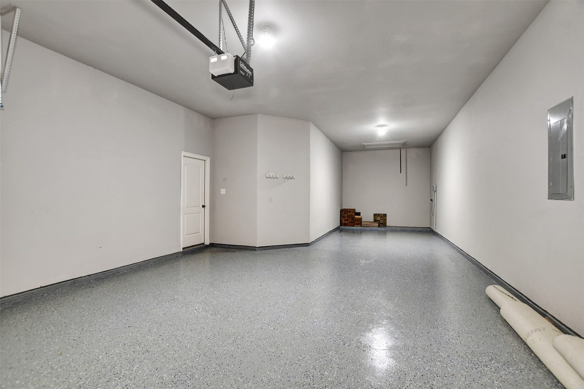 3 car garage with epoxy flooring, sprinkler system and extra storage area.
