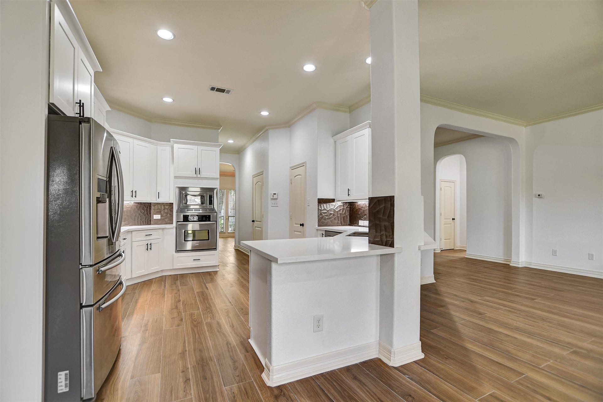 White counter tops with white cabinets make this newly redesigned kitchen very elegant and spacious.